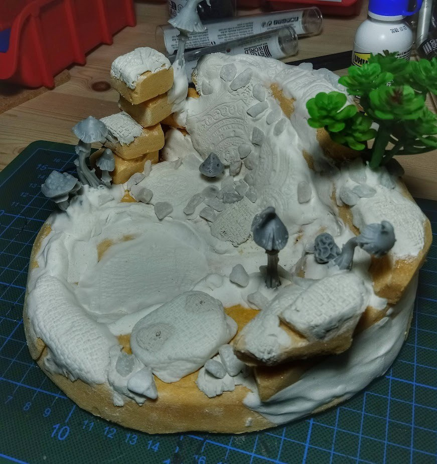 Diorama with putty, stones, mushrooms and a little plastic plant. Not primed yet.