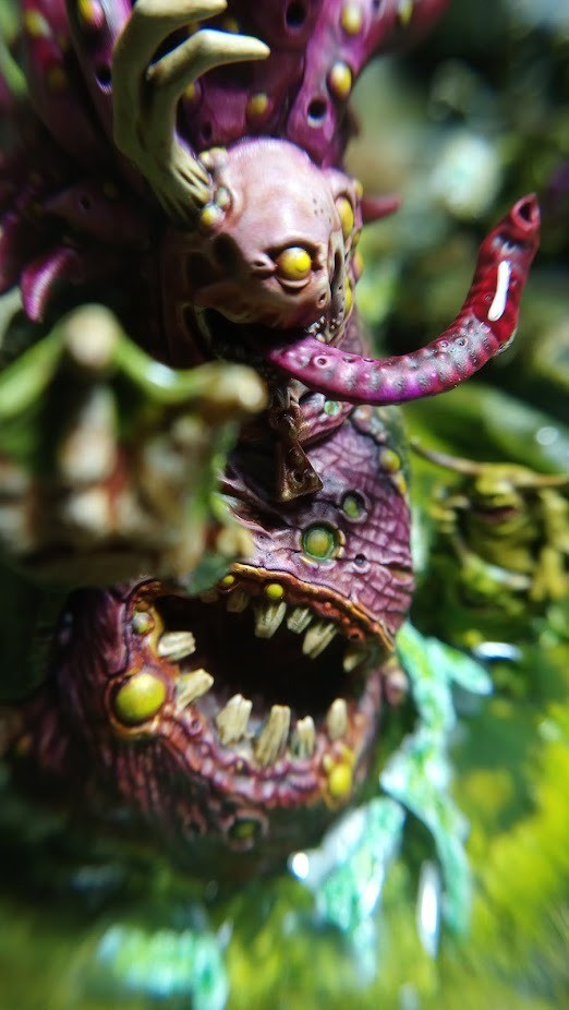 close-up of the Beast of Nurgle raising its paw. The Nurglings washing it are a bit out of focus.