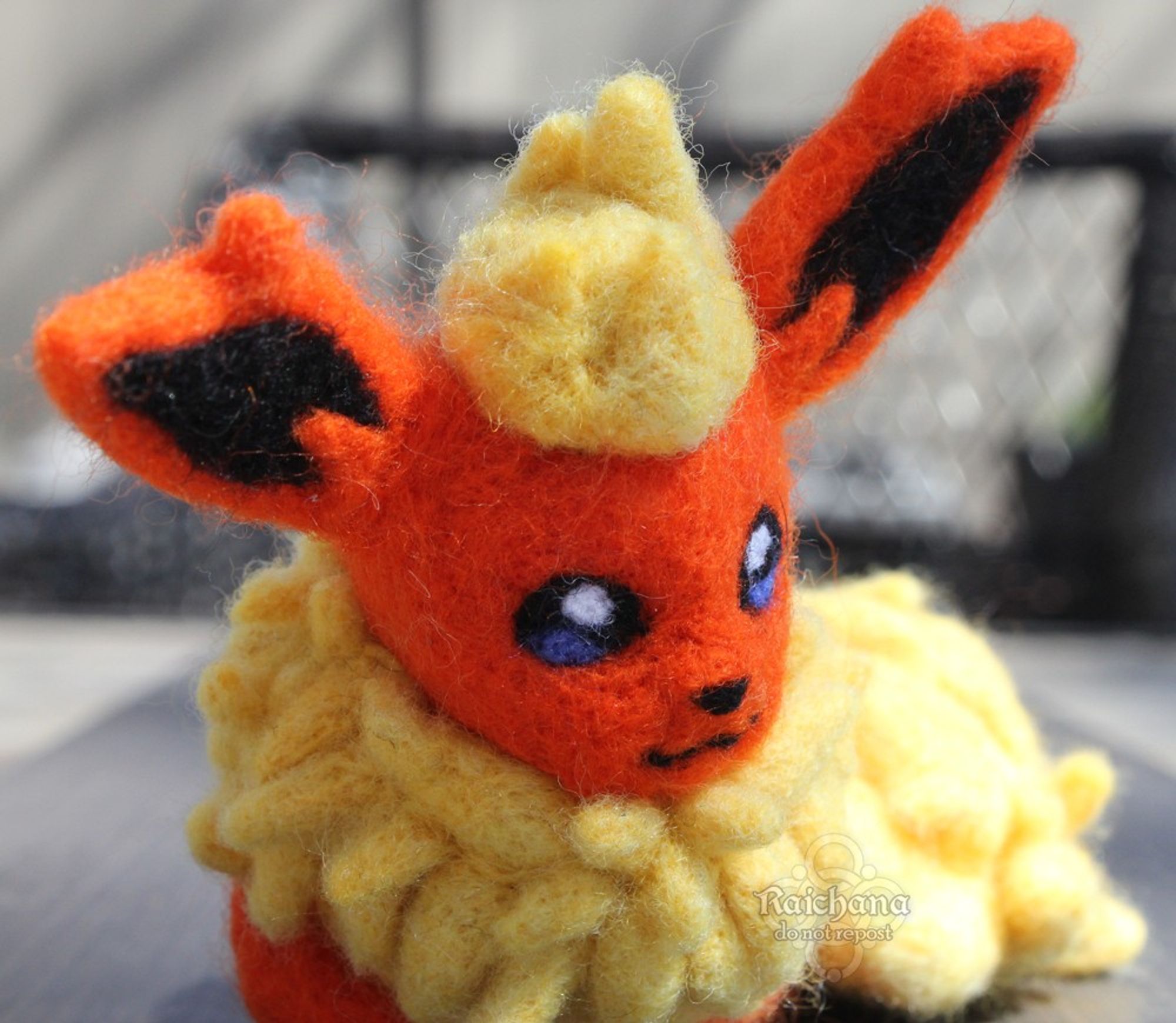 A felt of the pokemon Flareon in a loaf position.