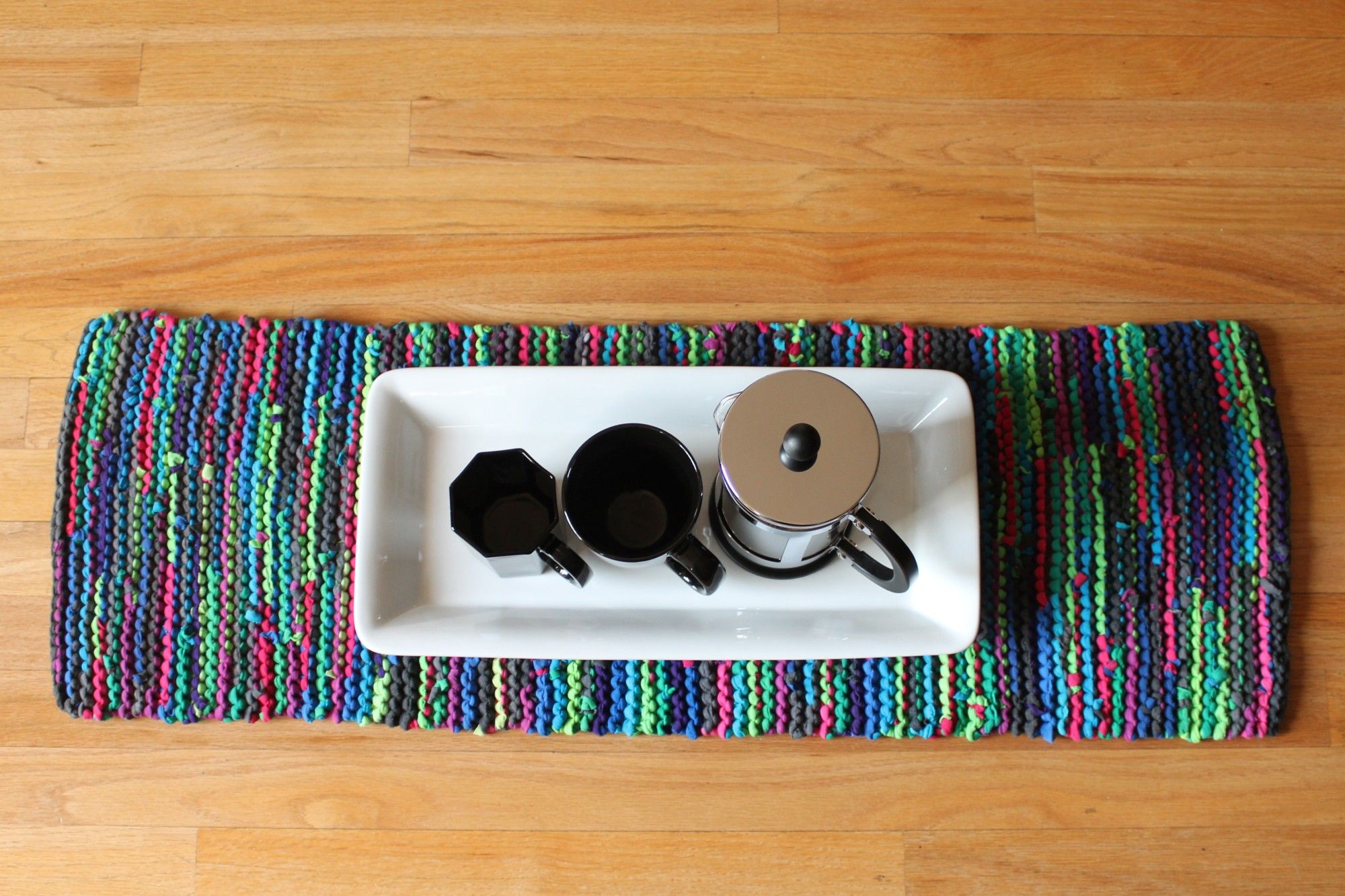 knitted table runner with coffee cups and french press