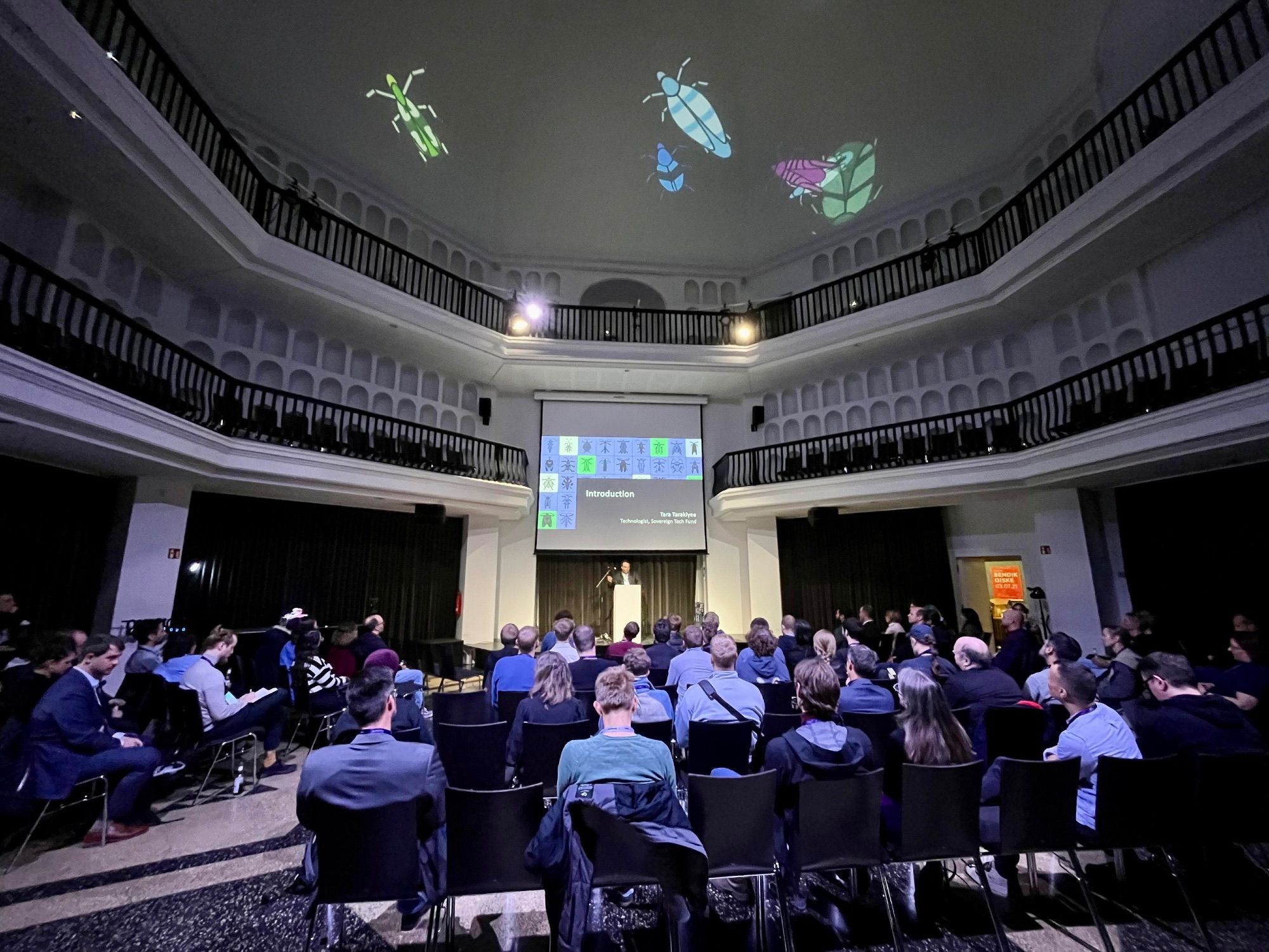 Tara Tarakiyee speaking at the event in Silent Green, beetles are visible and projected on the dome