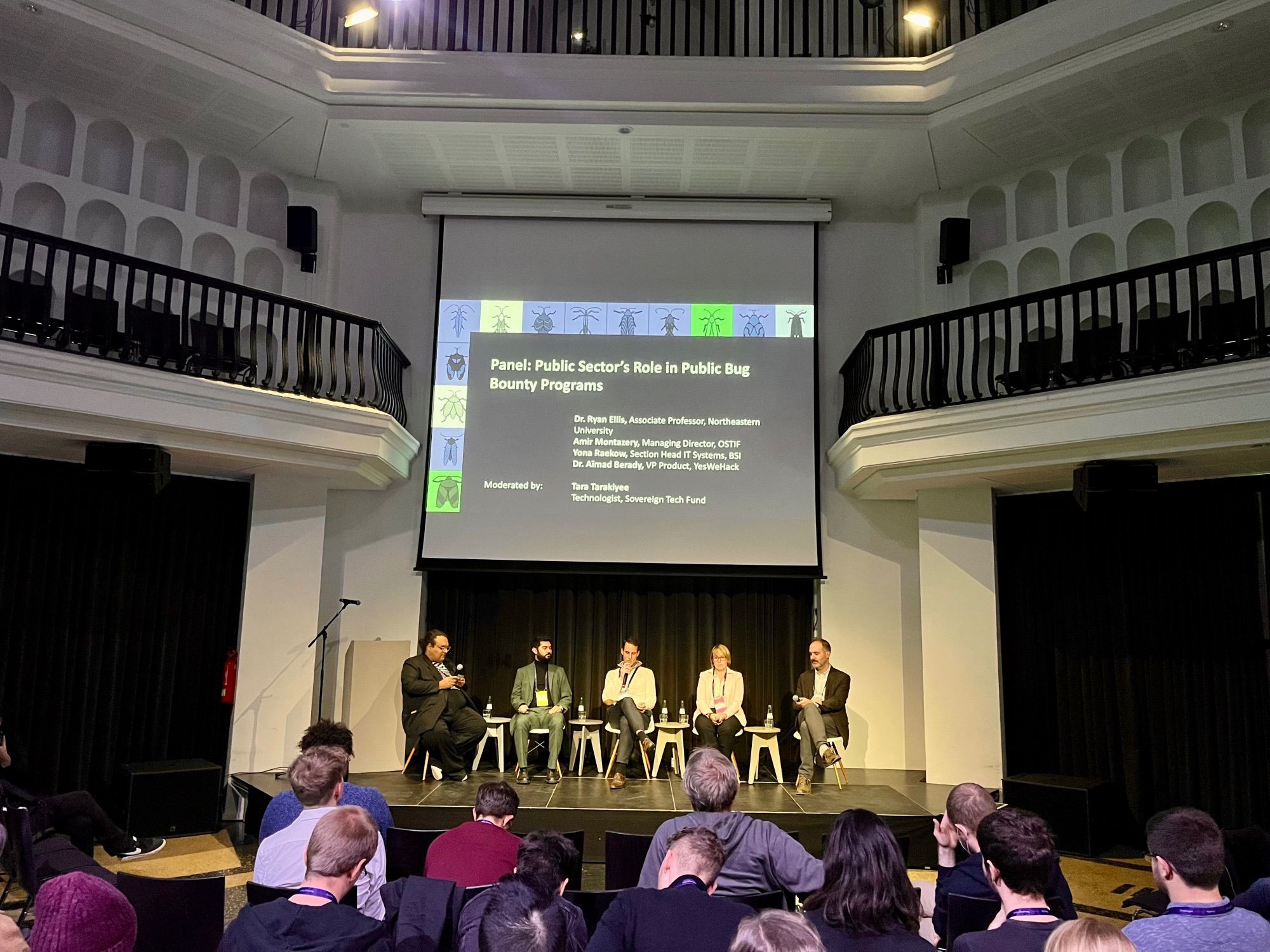 Frontal view of the panel on stage, seated left to right: Tara Tarakiyee, Amir Montazery, Dr. Aïmad Berady, Yona Raekow, and Dr. Ryan Ellis.