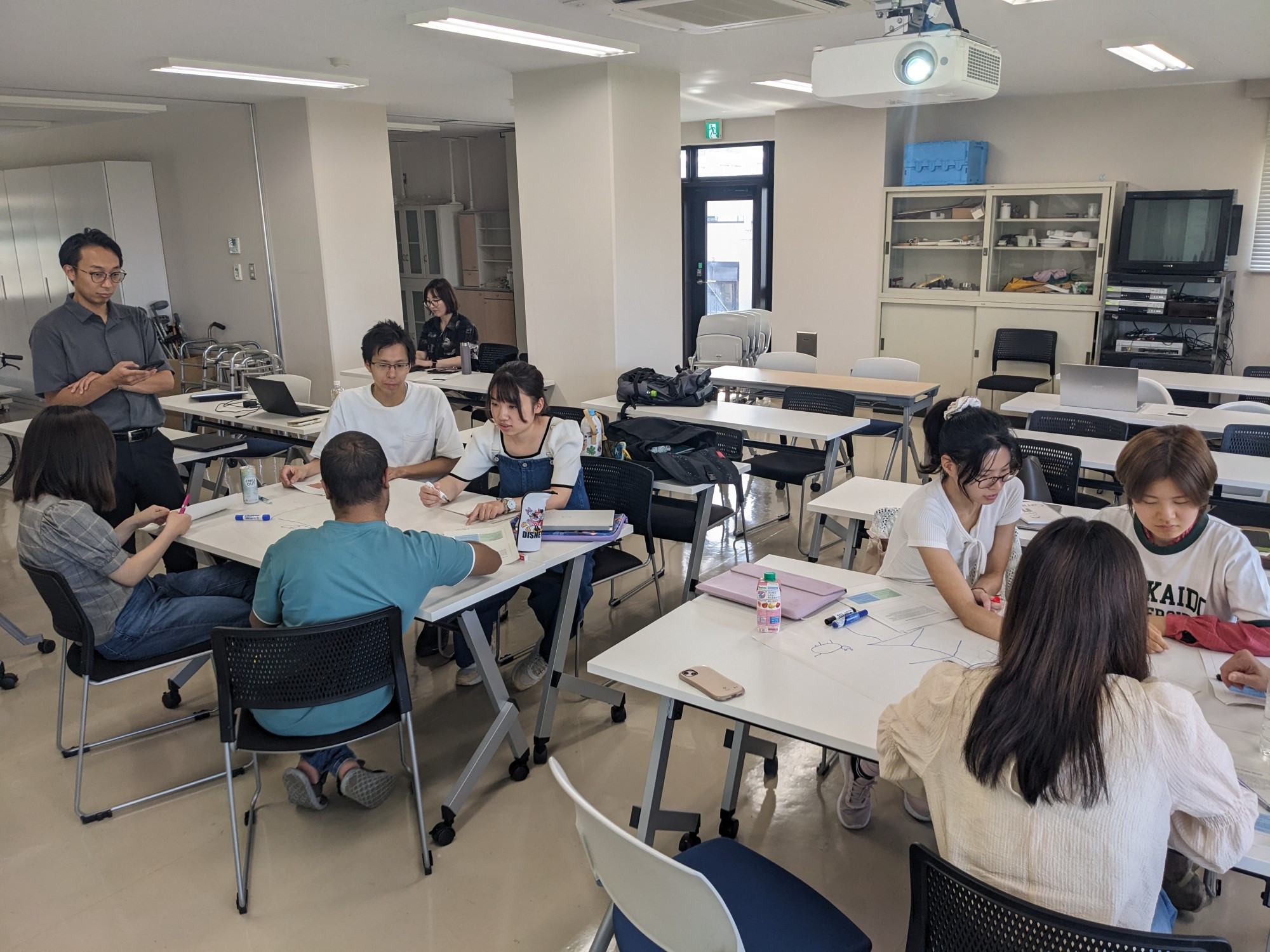 The students working on another case study on flip chart paper, supervised by Nagoya Hasegawa, a physiotherapist faculty member from Hokkaido University