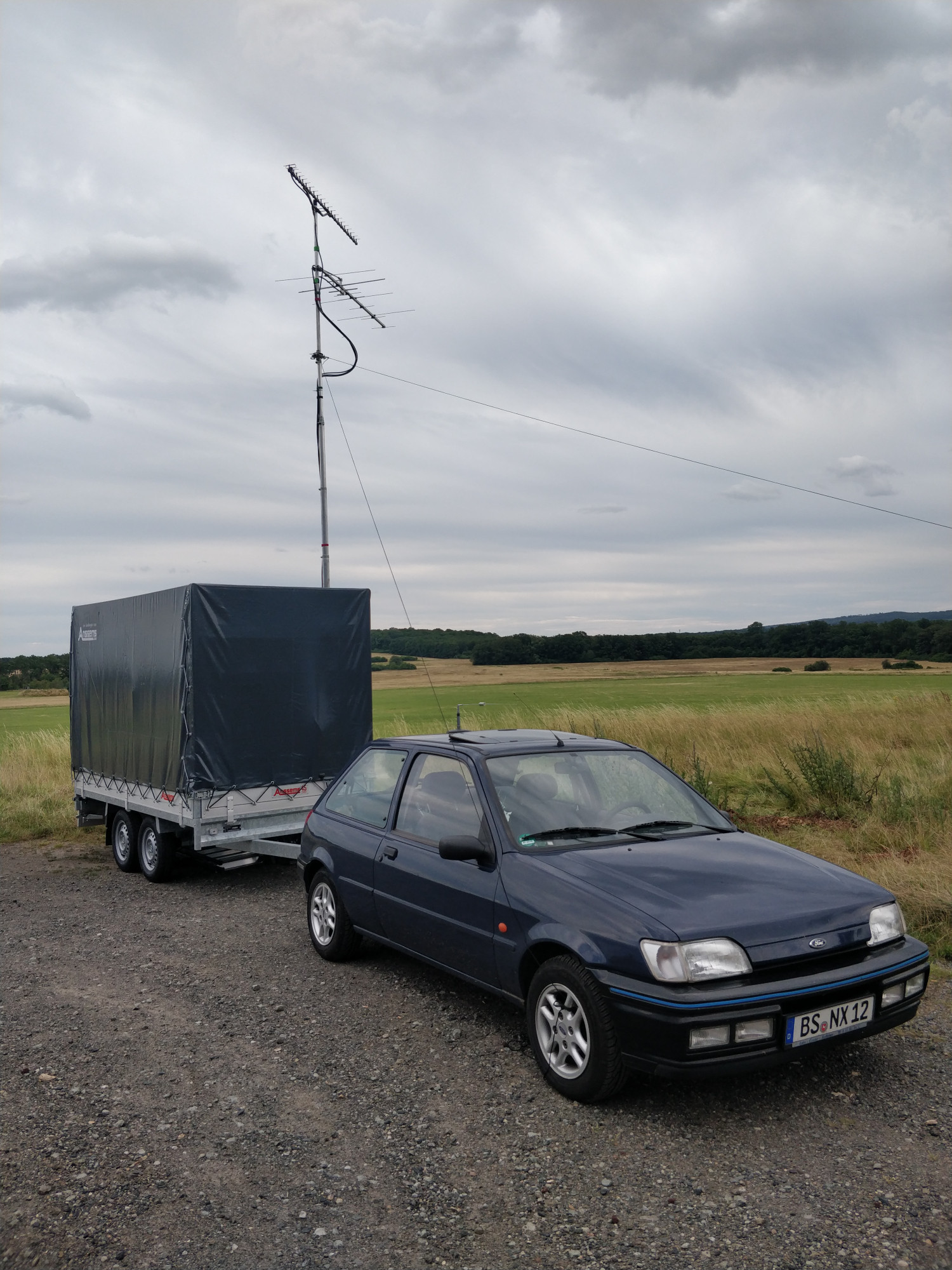 Das Gespann aus Anhänger und Fiesta steht am Feldrand. Die Antenne ist schon aufgebaut