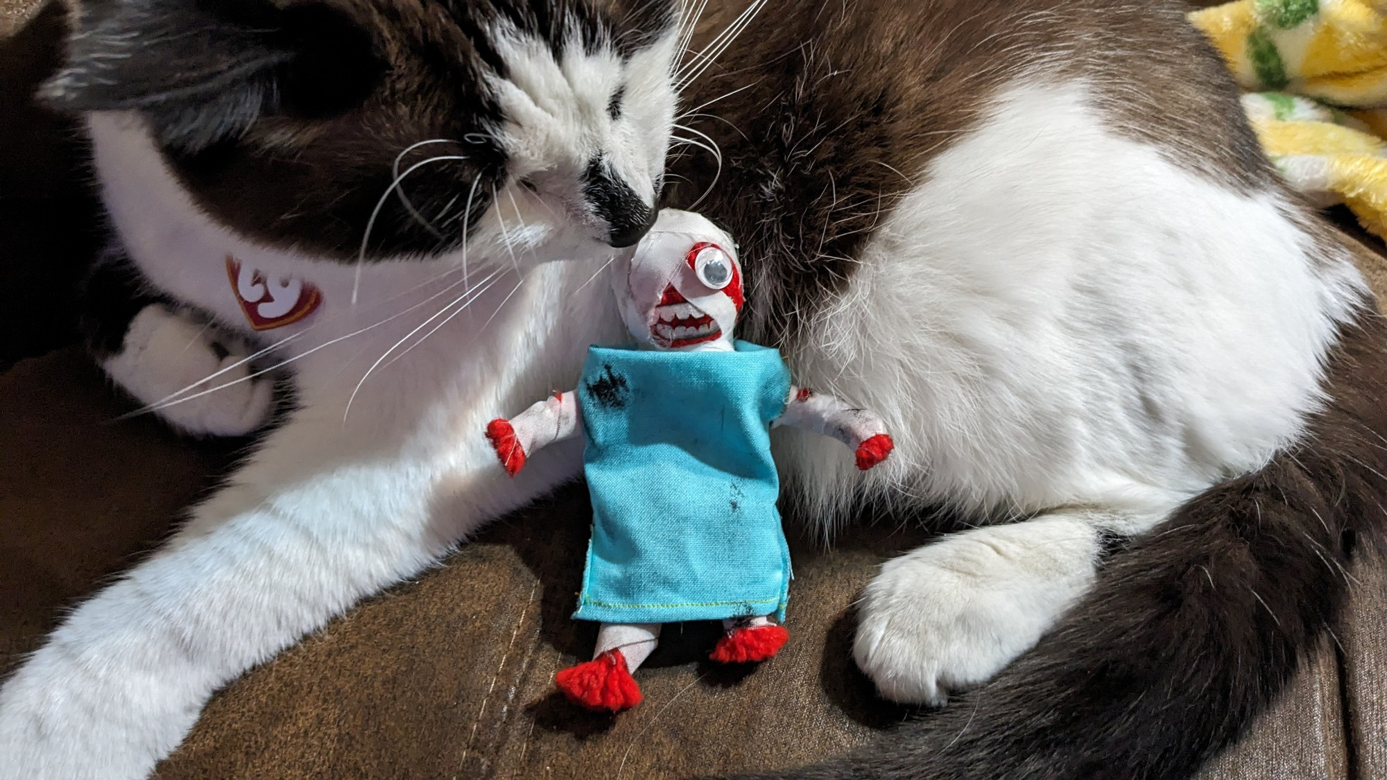 A yarn doll of Curly from the game Mouthwashing posed with a cat