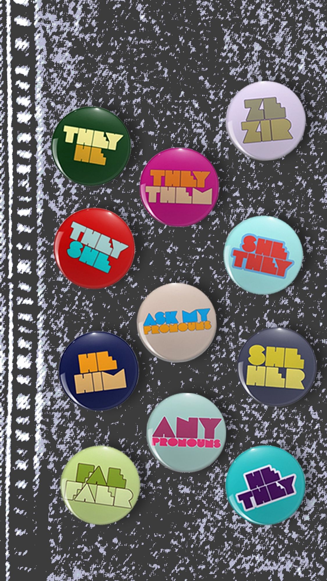 11 different colorful pronoun pinback badges on a gray denim background. Included are they/he, they/she, they/them, she/they, he/they, he/him, she/her, ze/zir, fae/faer, ask my pronouns, and any pronouns