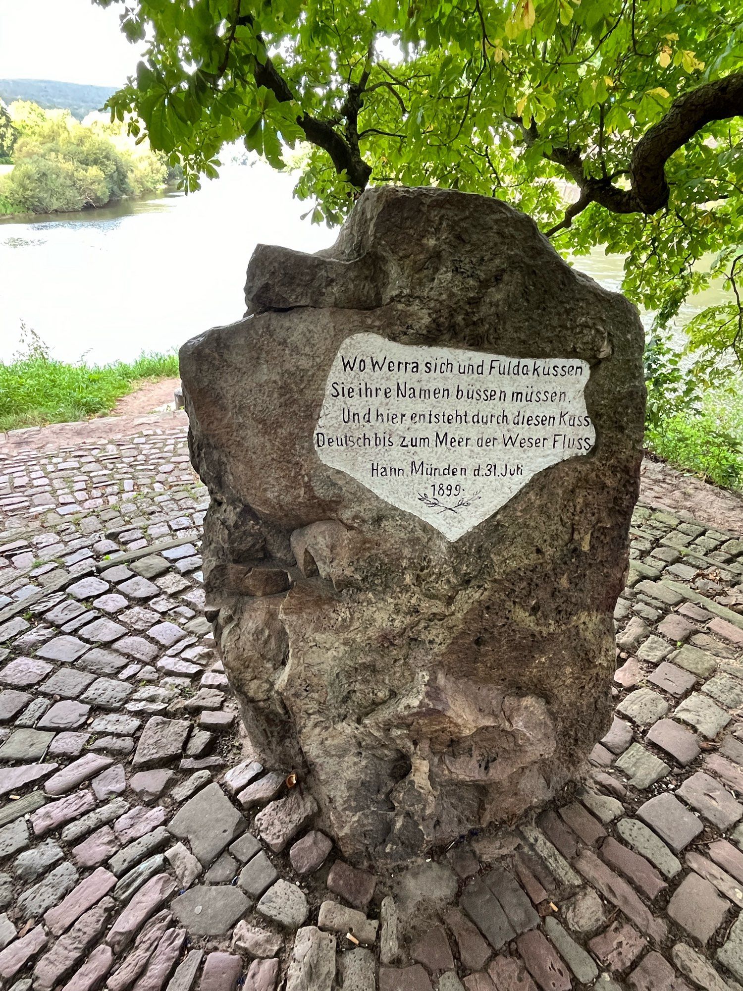 Der „Weserstein“

Wo Werra sich und Fulda küssen
Sie ihre Namen büßen müssen
Und hier entsteht durch diesen Kuss
Deutsch bis zum Meer der Weserfluss

Hann. Münden d. 31. Juli 1899