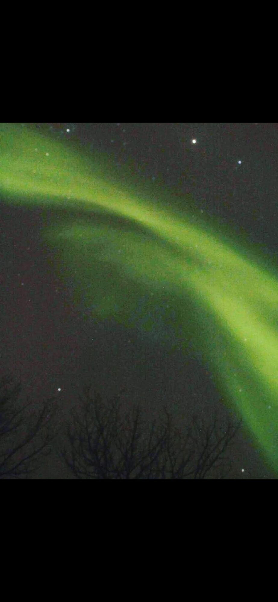 Green northern lighf strip in a dark purple sky. Taken in Norway.