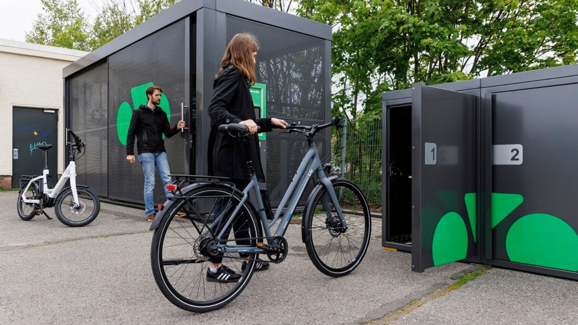 Frau stellt Fahrrad in einer ParkYourBike-Einzelbox in Berlin Friedrichsfelde-Ost ein.