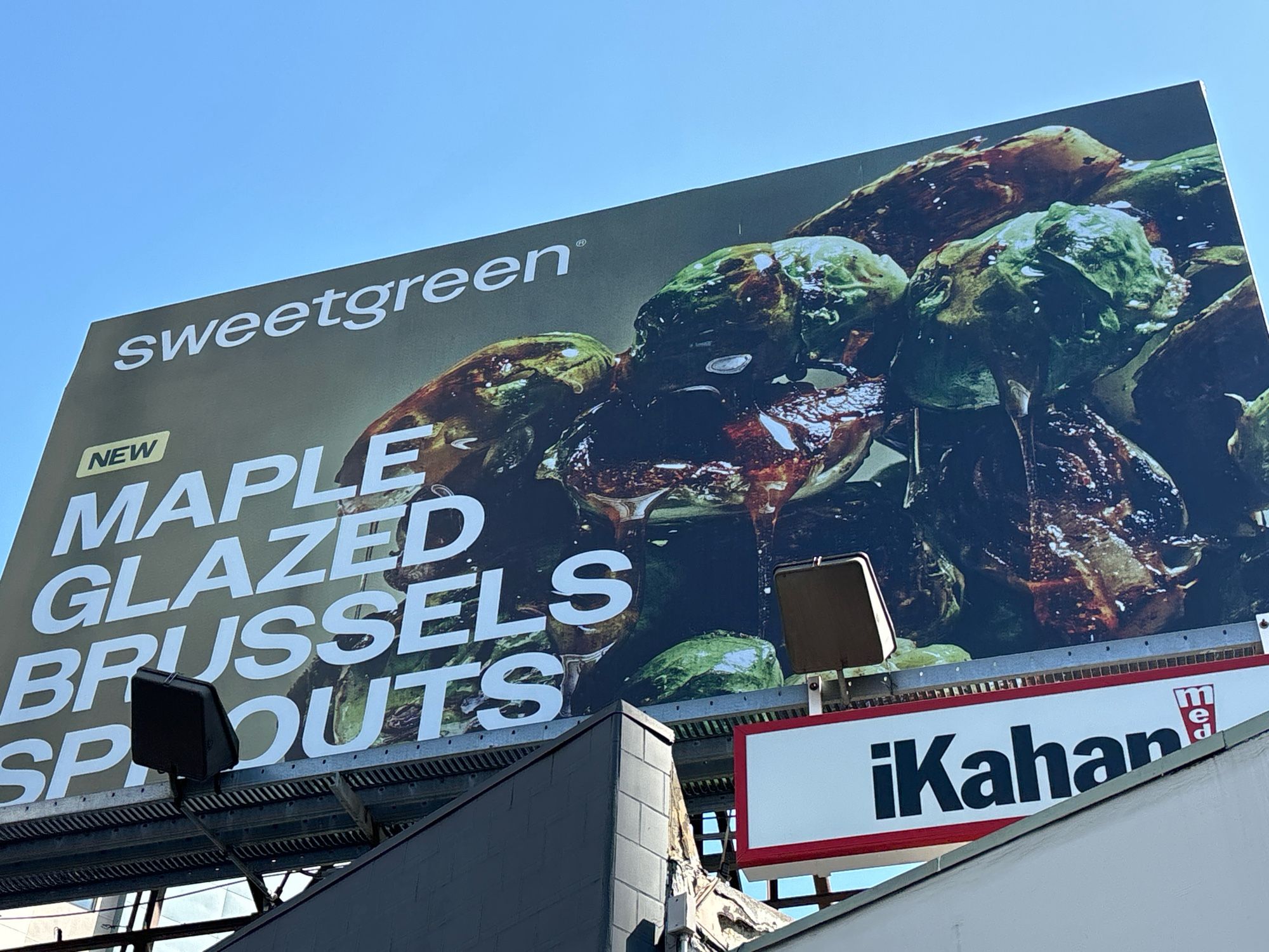 A billboard for sweetgreen featuring Brussels sprouts dripping with open gooey splattergore