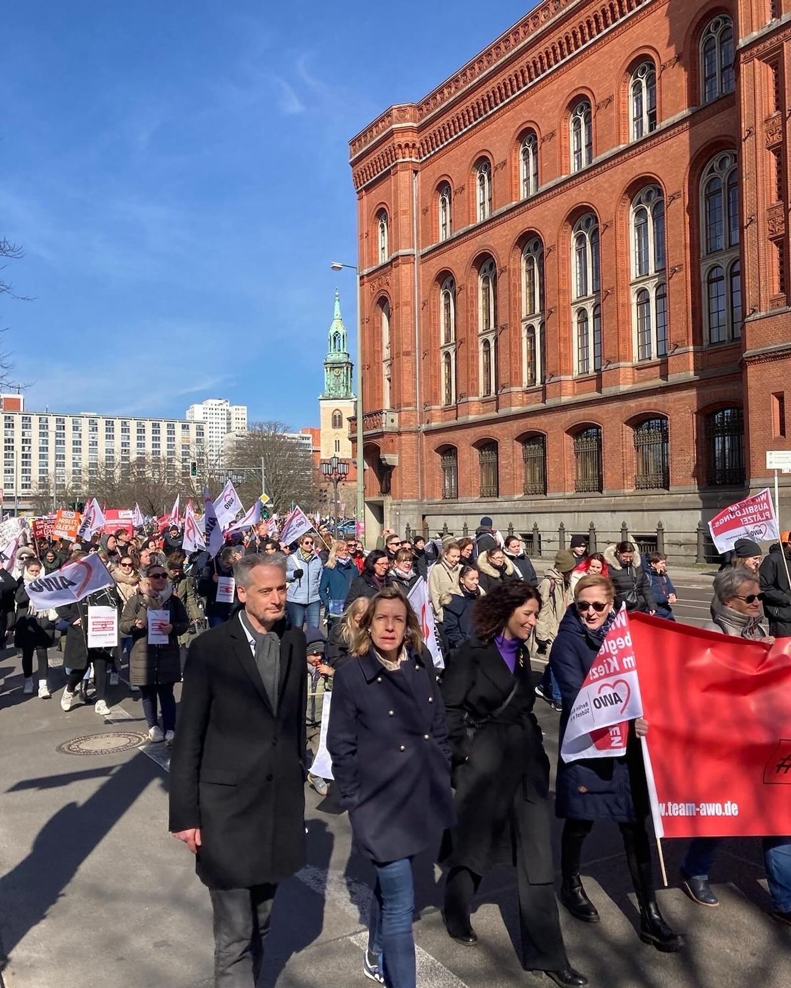 Fraktionsvorsitzende Bettina Jarasch auf einer Demo der freien Träger in Berlin. Sie läuft neben einem Banner mit den Abgeordneten Christoph Wapler und Catherina Pieroth.