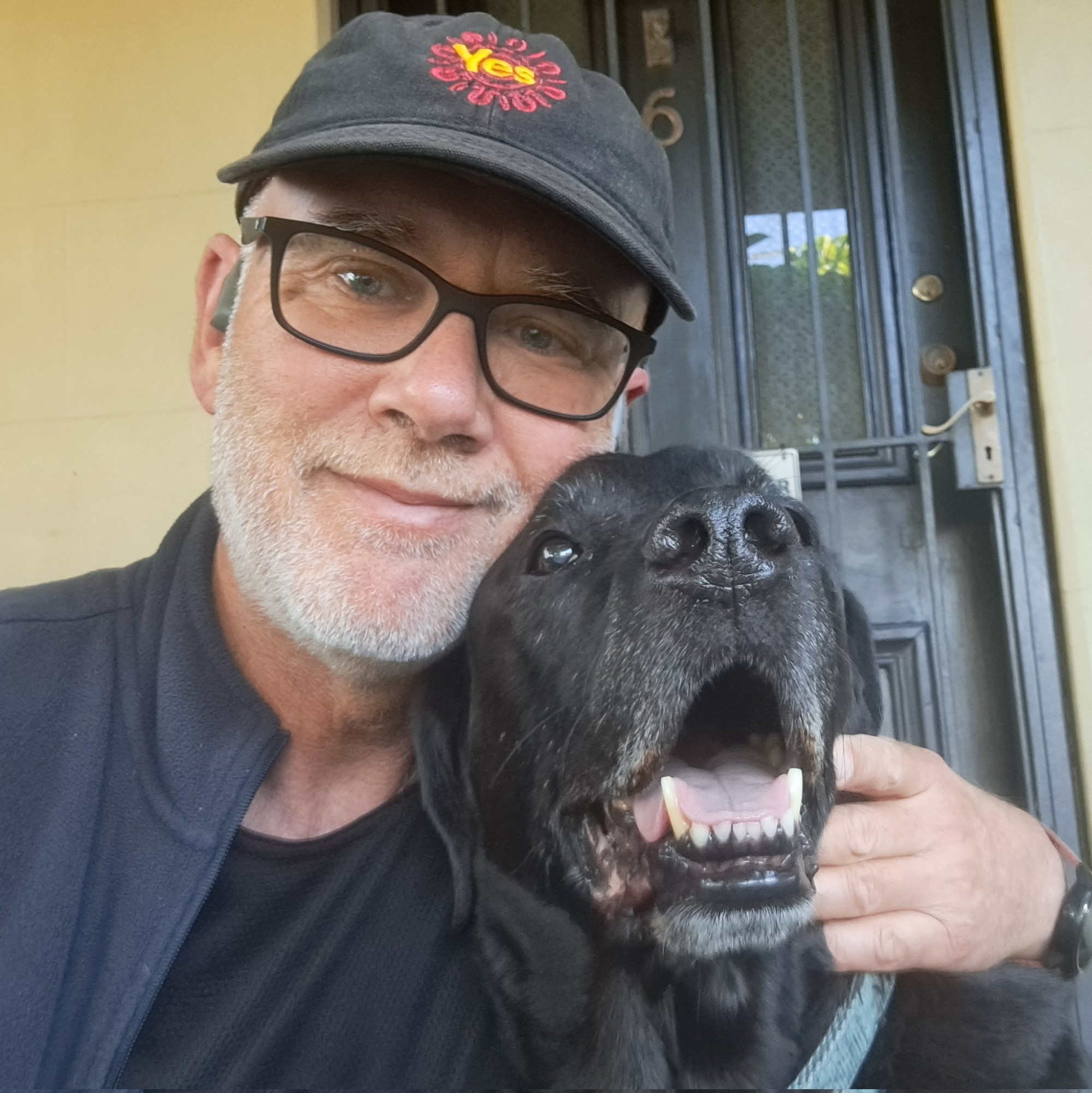 Selfie hugging my black labrador Jet.