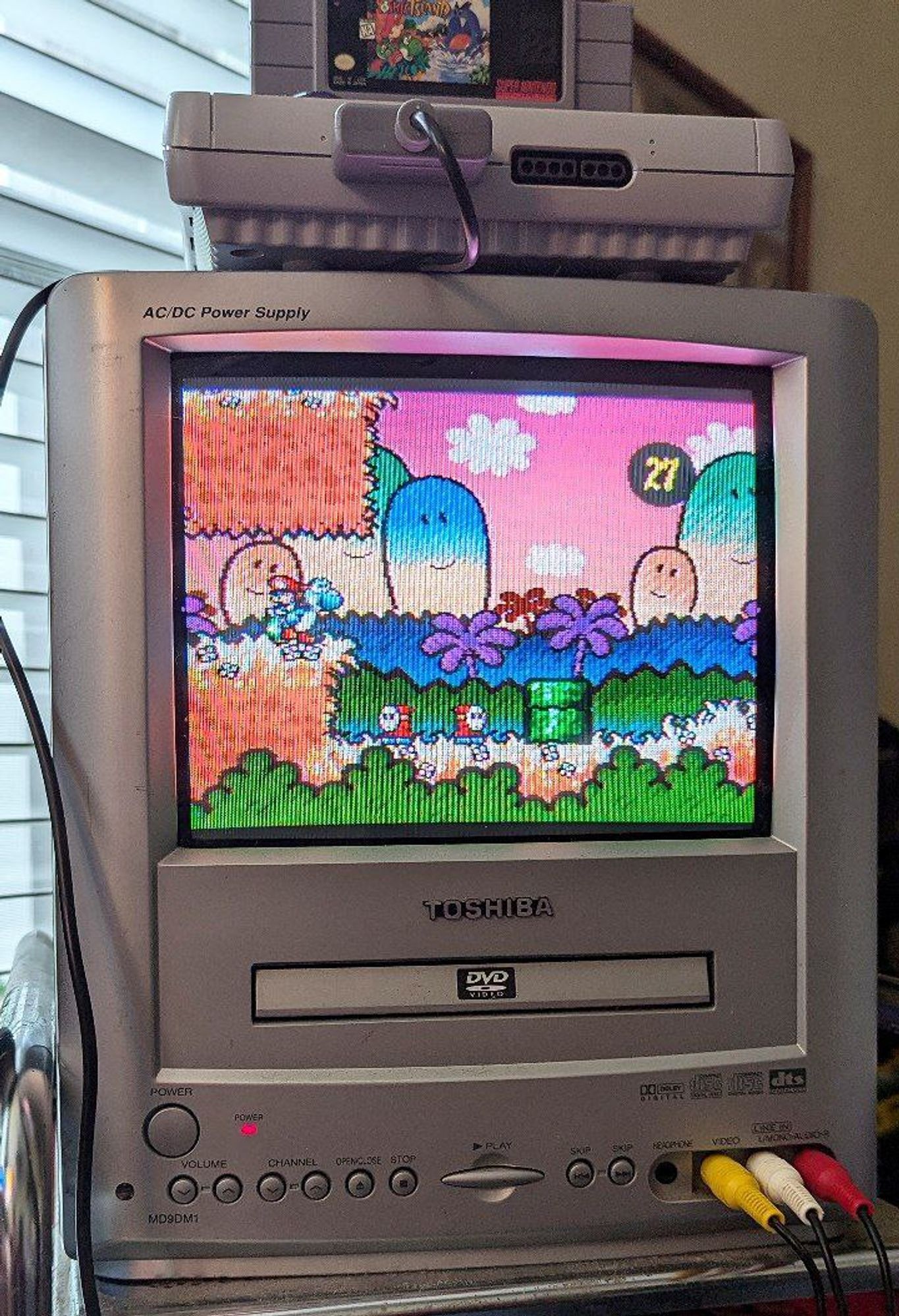 Yoshi's Island for the Super Nintendo being played on a small CRT television