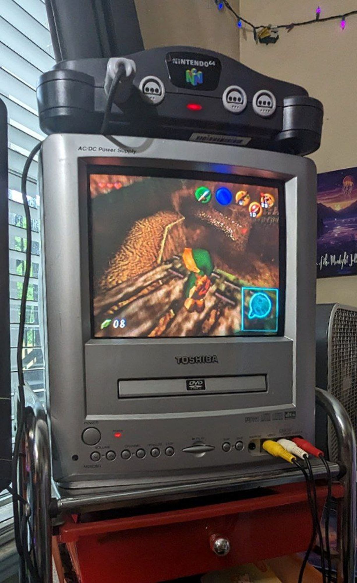 A Nintendo 64 console sitting atop a small 9 inch CRT television. The Legend of Zelda: Ocarina of Time is being played on it.