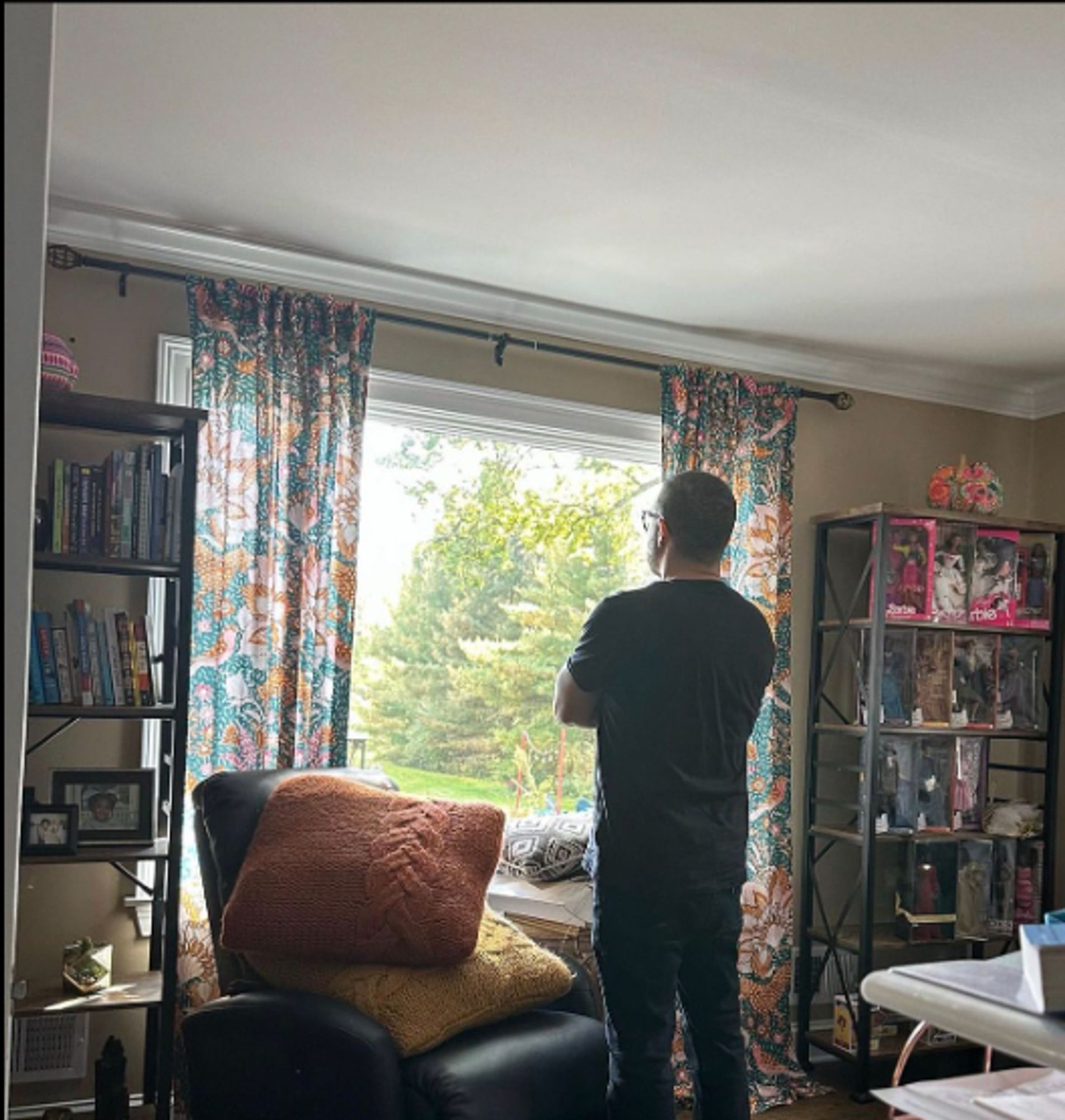 Shaun King's infamous 'just snapped a pic' as he stares out the window pondering his part in the growing Gaza genocide. His collector Barbies on the shelf next to him look on with fake smiles because they too know he ain't shit.