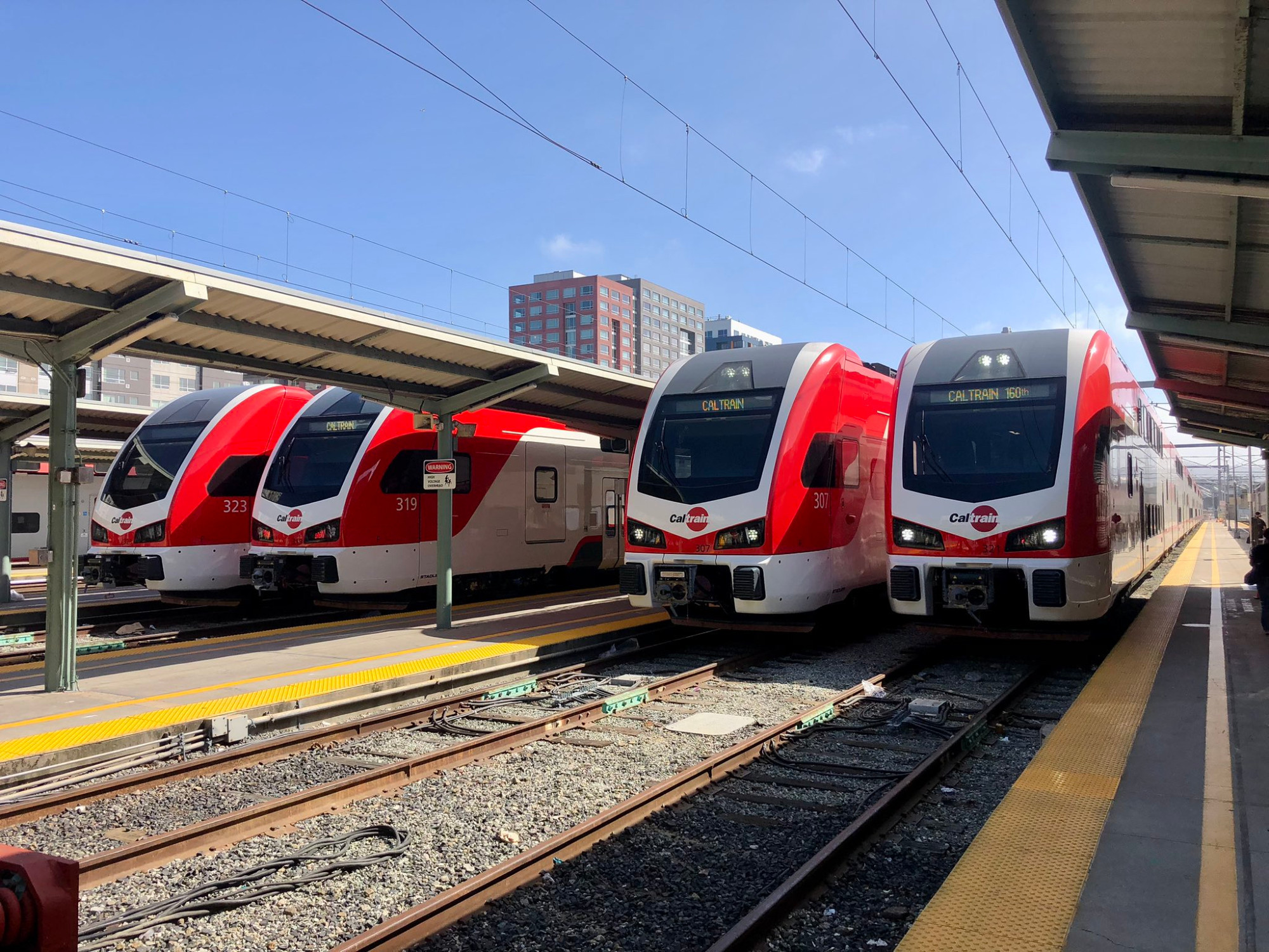 four shiny new EMU Trains lined up at a passenger rail terminal