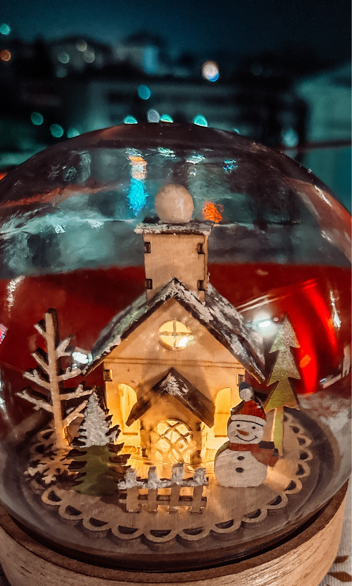 The same Christmas decoration from the previous posting in this thread, but this time the transparent ball is perfectly positioned! 
Great vie inte the dark behind the ball which shows a winter seen made out of wooden figures. A little tree and a snowman is standing next to the little house. There is even a light brighten up the house from the inside