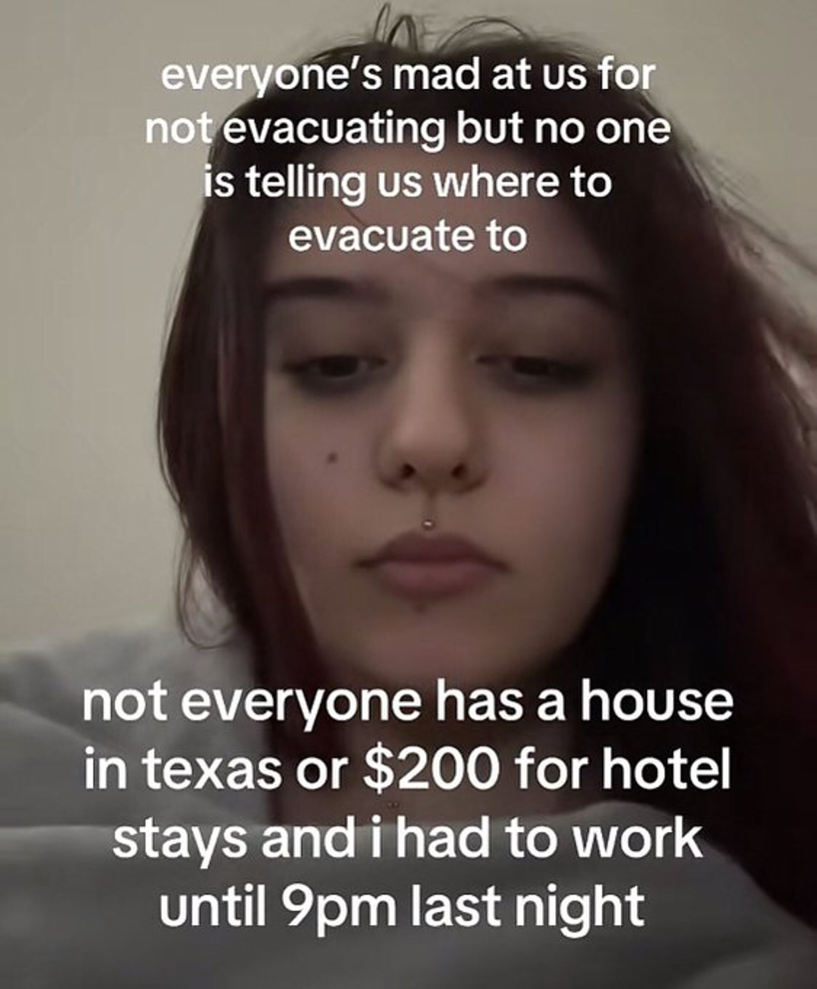 Tired looking woman with caption, "everyone's mad at us for not evacuating but no one is telling us where to evacuate to, not everyone has a house in texas or $200 for hotel stays and i had to work until 9pm last night"