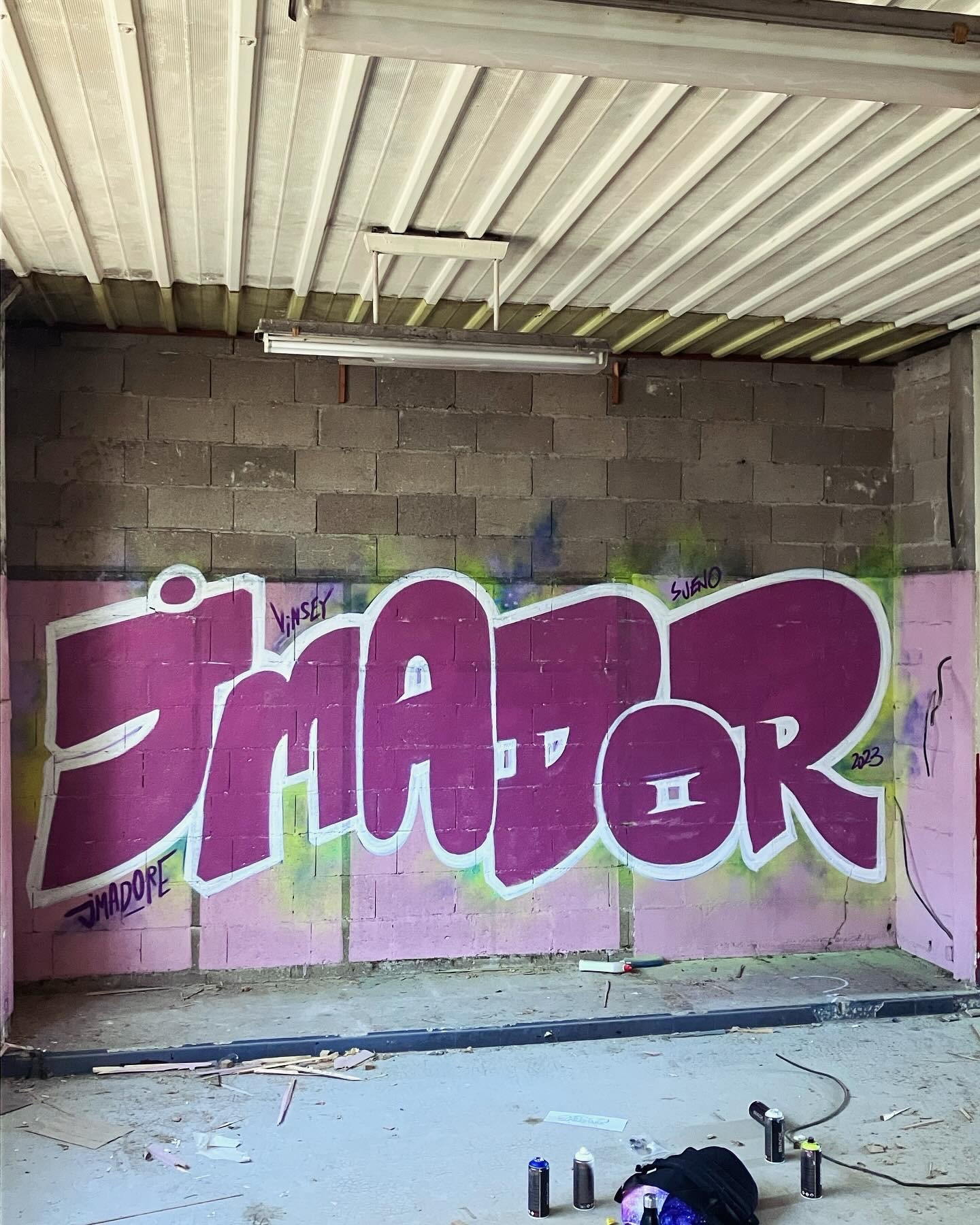 Graffiti « JMADOR » dans une pièce de bâtiment en démolition