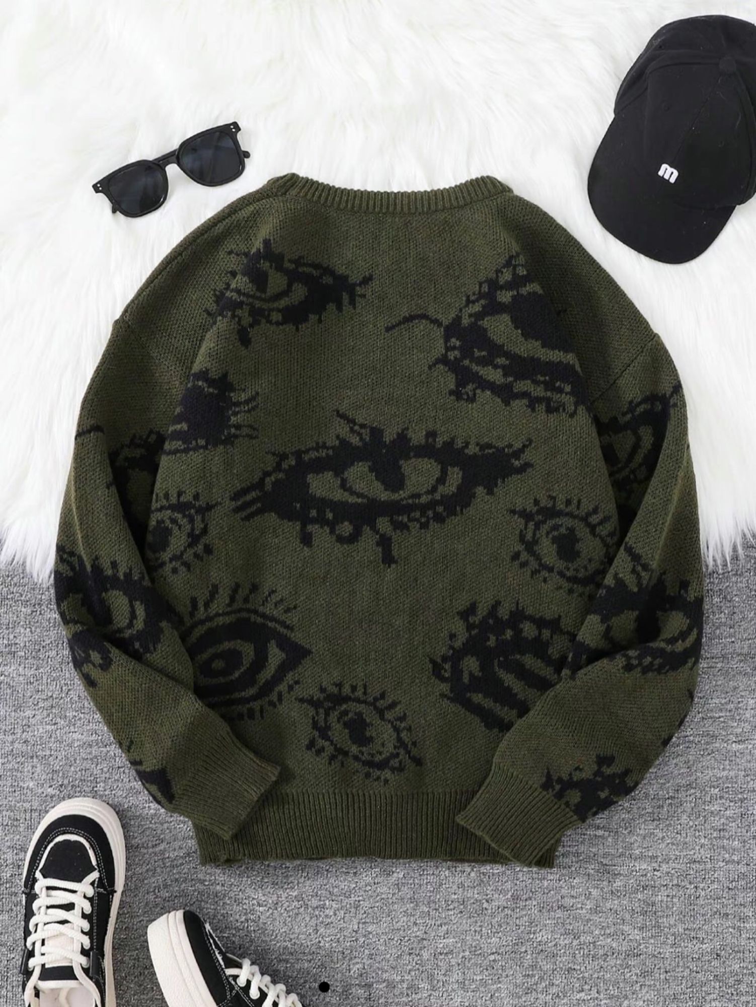 Forest green jacquard knit sweater with different styles eyes patterned all over it.