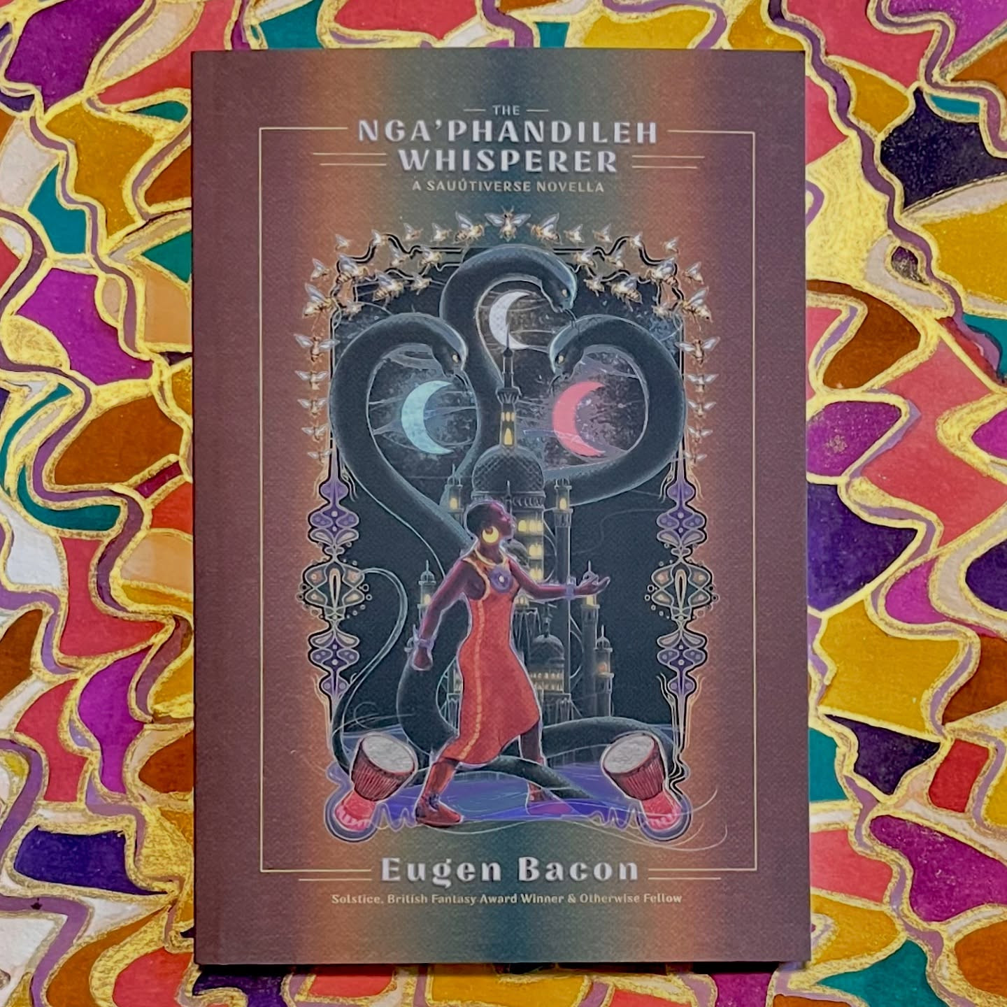 The Nga’phandileh Whisperer by Eugen Bacon, cover art by Stephen Embleton
Background abstract mixed media art by Jendia Gammon