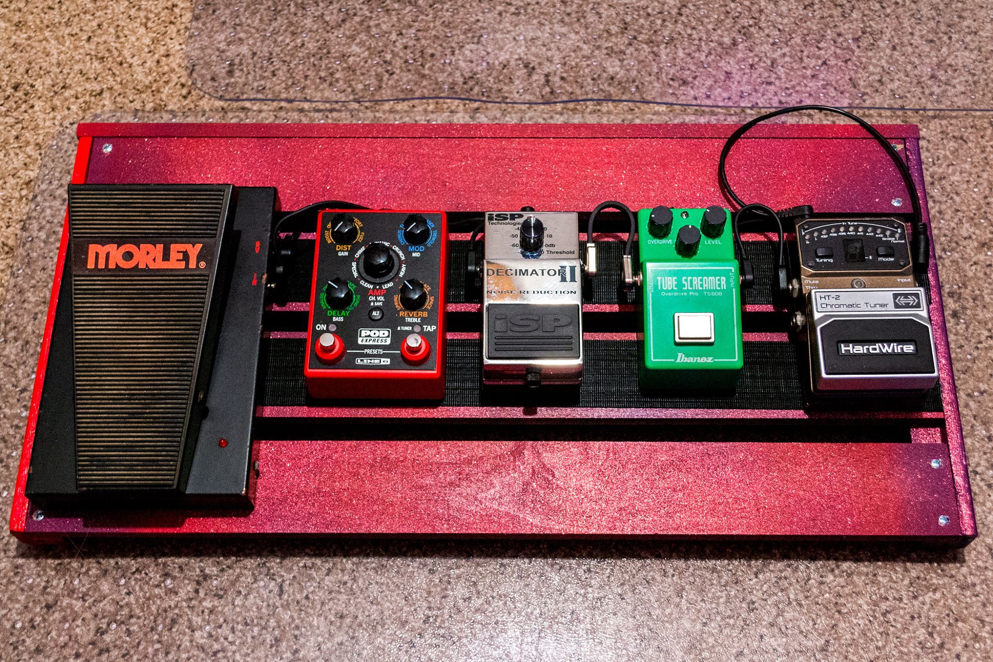 The "finished" project. This pedalboard is 25" wide, randomly painted purple & red, and the same pedals as the first pic. They are all connected both in audio and power