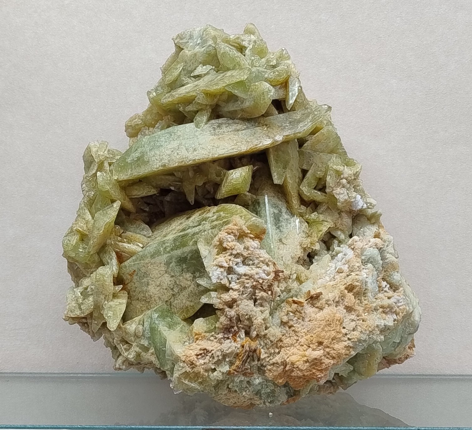 Large brazilianite specimen consisting of intergrown tabular crystals which are somewhat translucent and pale yellowish-green in colour. The crystals have a range of different sizes.

From Mendes Pimenthal, Rio Dolce Minas Gerais, Brazil. Specimen number BM.1964,648. Specimen on display in the Natural History Museum, London.