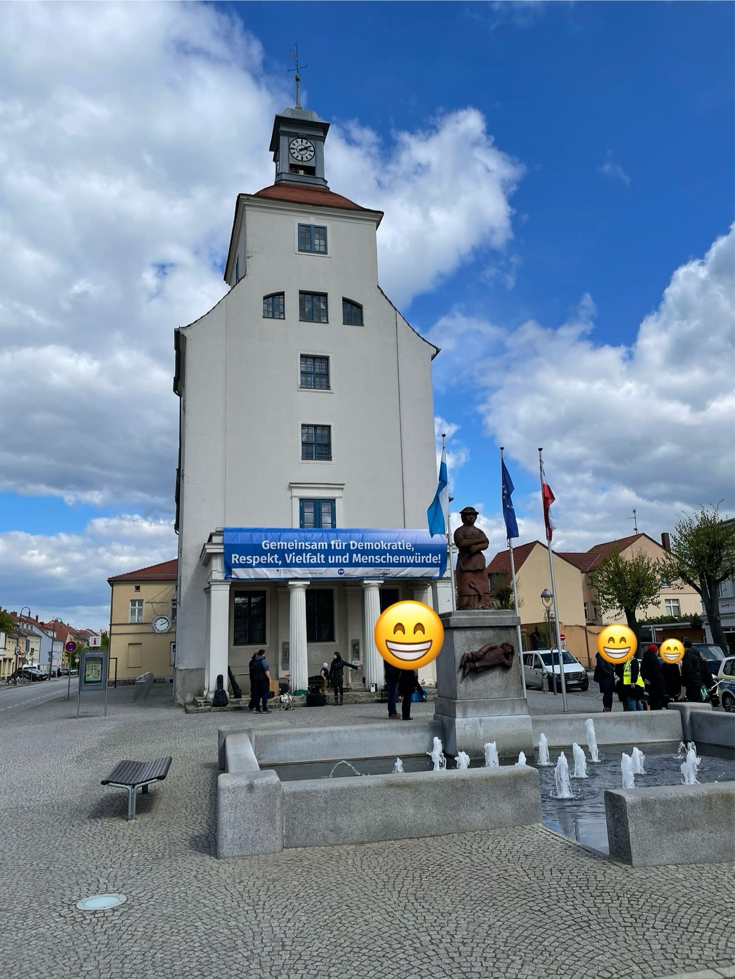 Blick auf das Rathaus vor der Demo, erste Organisatoren bauen auf. Vom Balkon hängt ein Banner mit den Worten “Gemeinsam für Demokratie, Respekt, Vielfalt und Menschenwürde.” Im Vordergrund ein Springbrunnen mit dem Namen "Sabinchenbrunnen”.