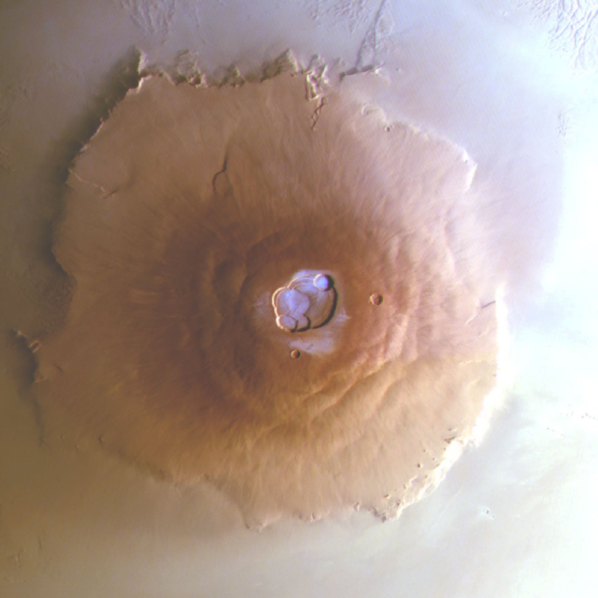 Cette image montre Olympus Mons. Ce volcan mesure environ 600 km de diamètre. Cette image a été obtenue tôt le matin (7h20, heure solaire locale, LST) par la caméra stéréo haute résolution à bord de Mars Express de l'ESA, et prise dans le cadre d'une nouvelle recherche révélant pour la première fois du gel d'eau dans ses caldeiras supérieures.