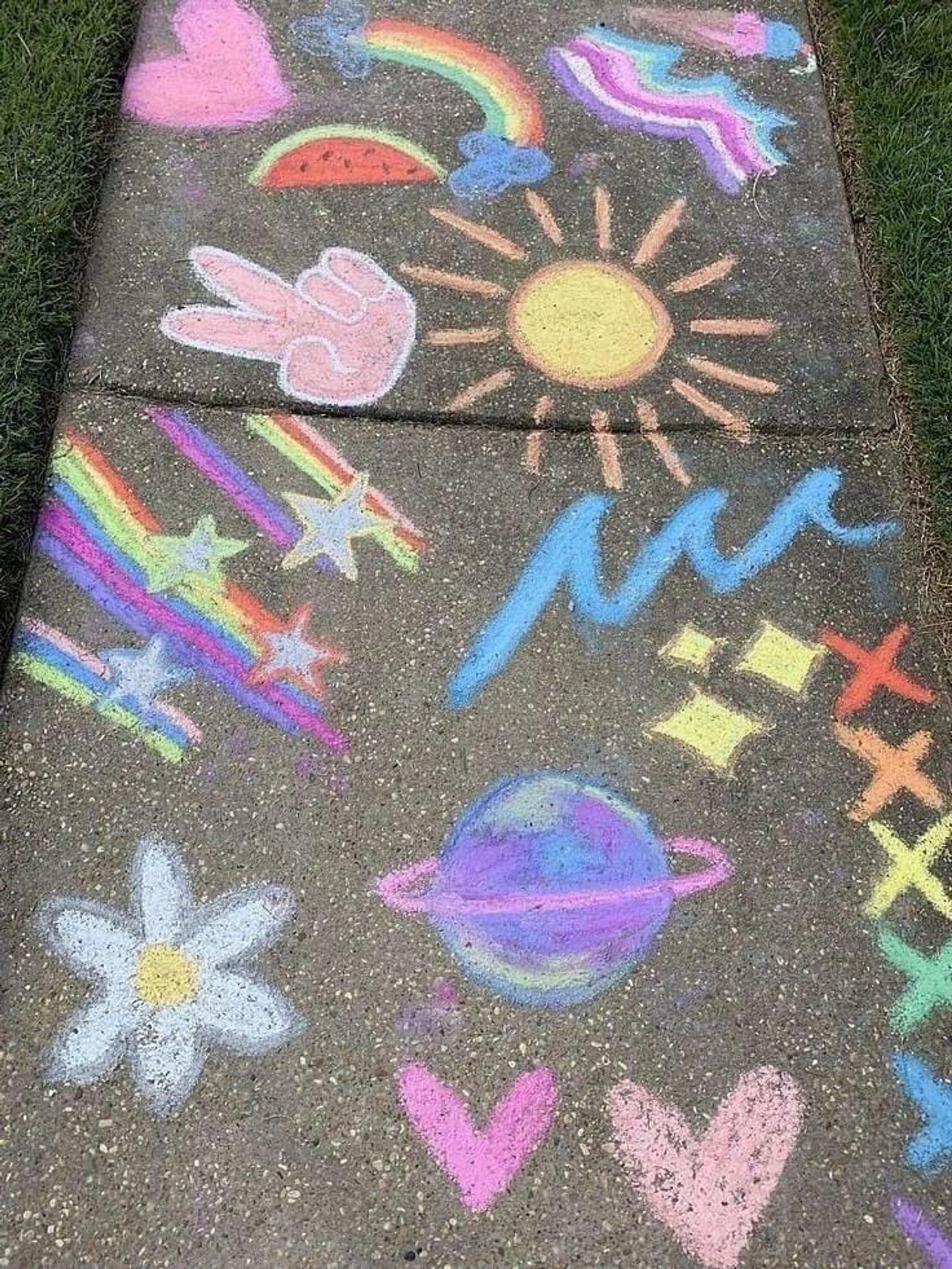 Sidewalk chalk drawings of flowers hearts and outer space