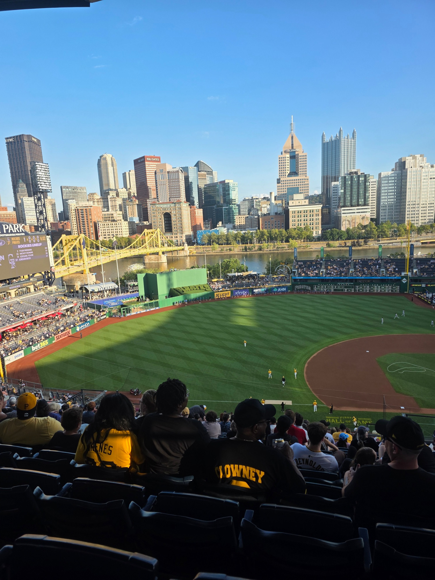 Pittsburgh skyline, including river, buildings, bridges, PNC park full of people