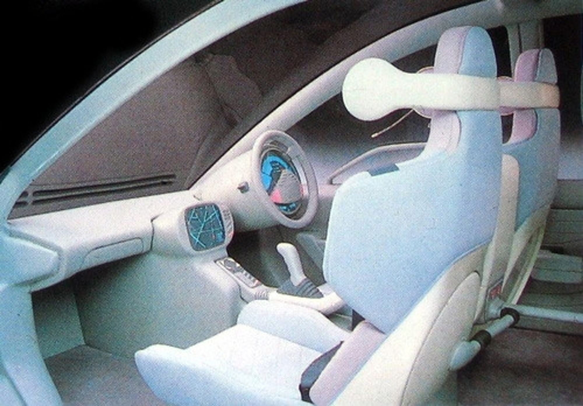 Front seats, pink and blue bucket seats, 1987 space age steering wheel and center console with green wireframe maps