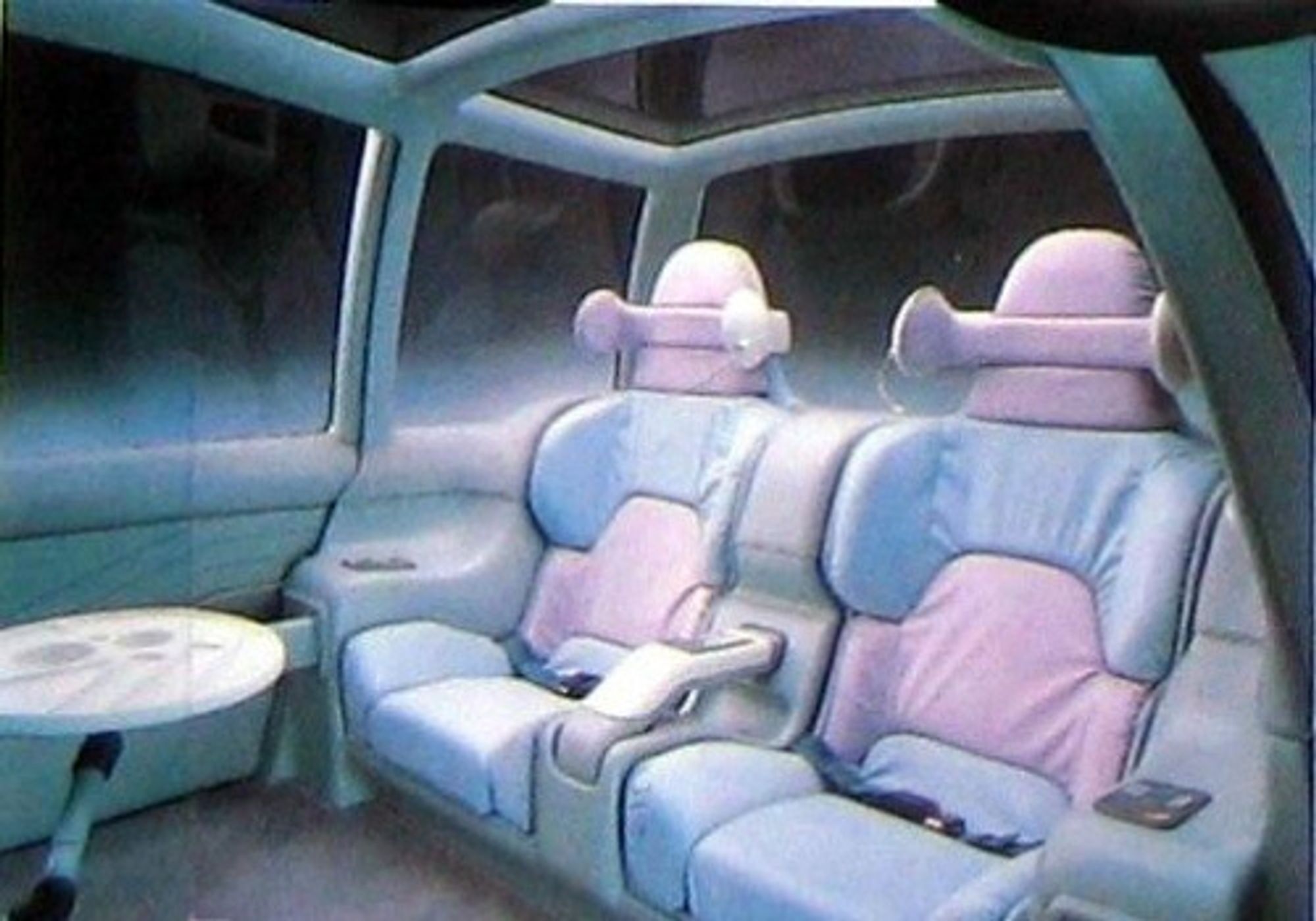 The rear seats, which are pink and blue leather and there's a little table