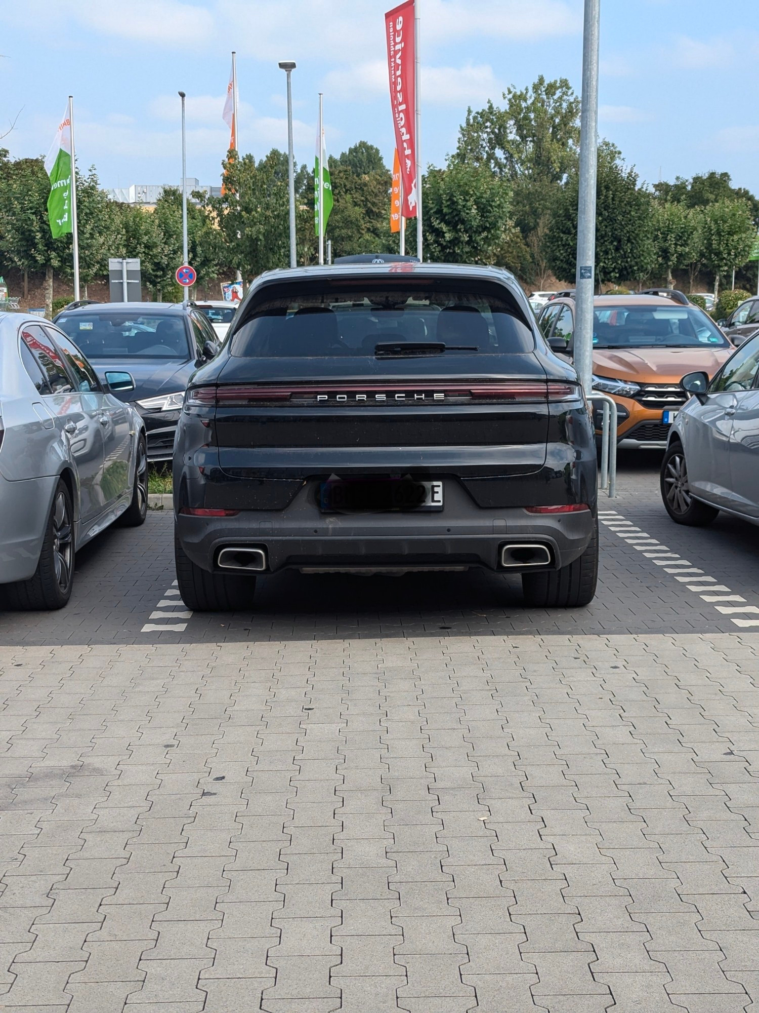 Porsche SUV mit zwei fetten Auspuffen und E Kennzeichen