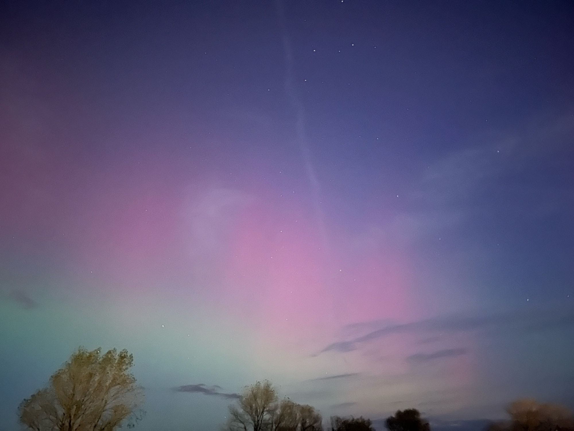 A series of iPhone images of the Northern Lights. Mainly pink bursts with some paler green elements below.