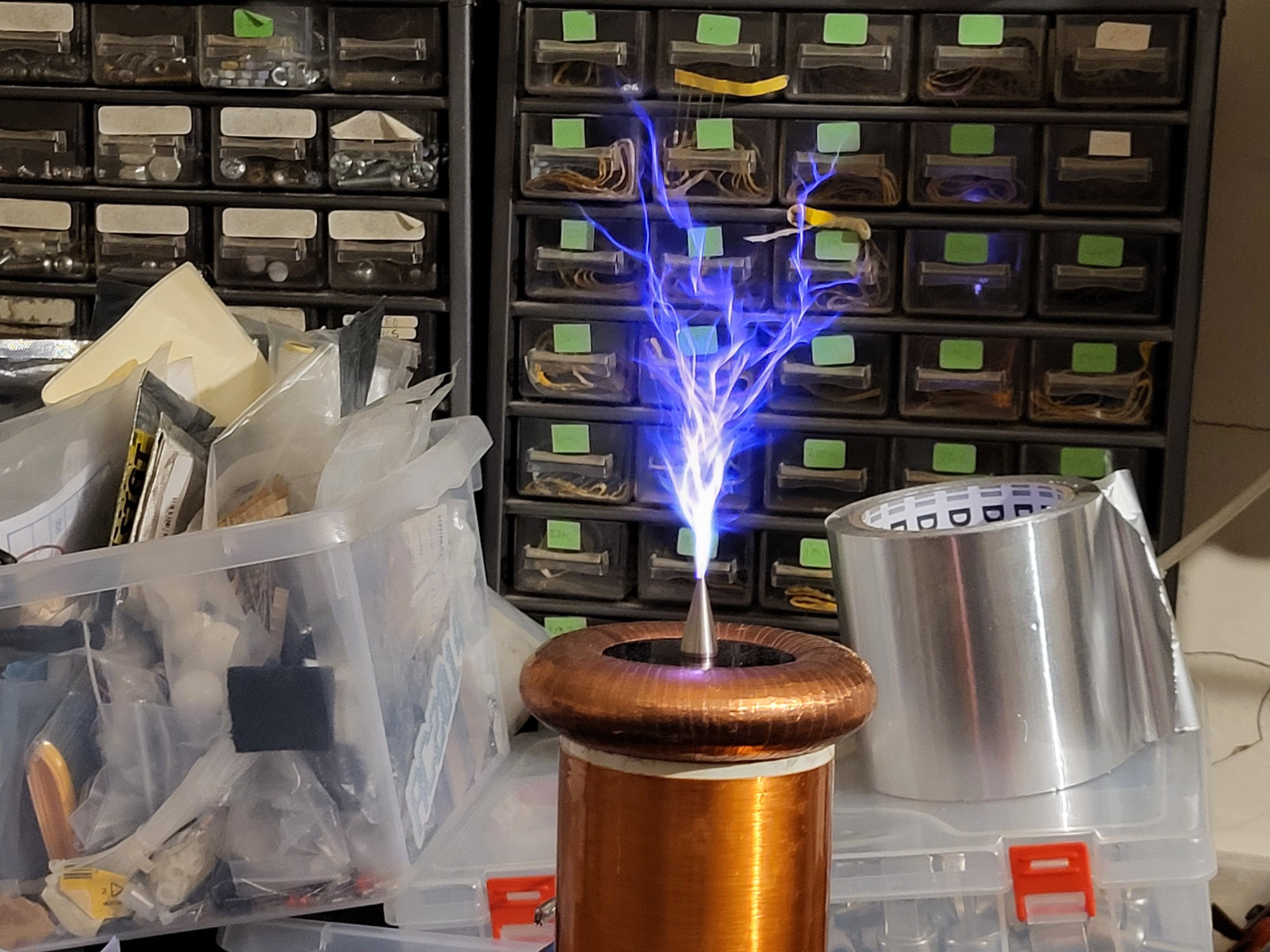 Large blue electrical discharge copper ring and the tesla coil secondary 

Small draws a real of alu. Tape and a box of msc crp. In the background. 