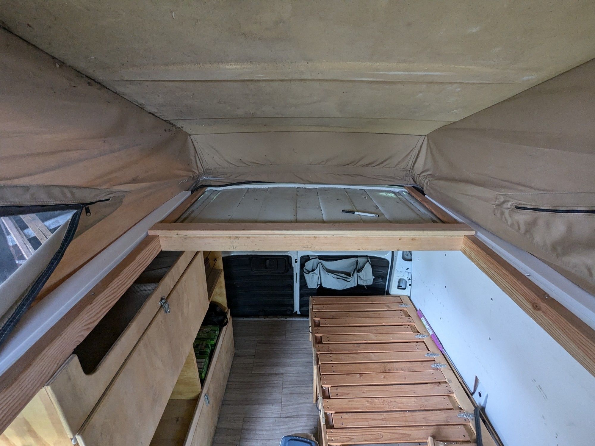 Wooden trim in a camper van under a pop up roof.