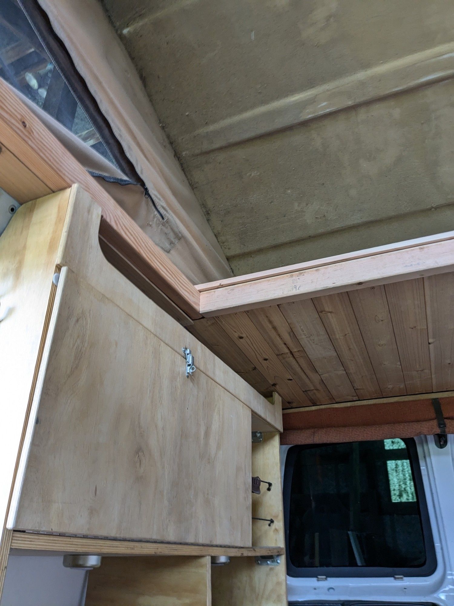 Wood trim and shelving installed on a camping van.