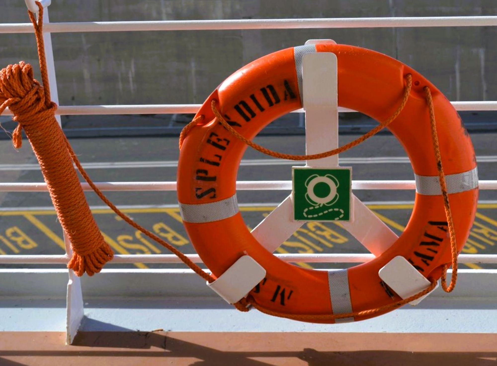 A large orange life ring on a ship containing the word 'Splendida' (English: Splendid... duh!) pictured together with a bundle of orange rope tied tightly as if in a number one serves to create an overall image of the number 10.