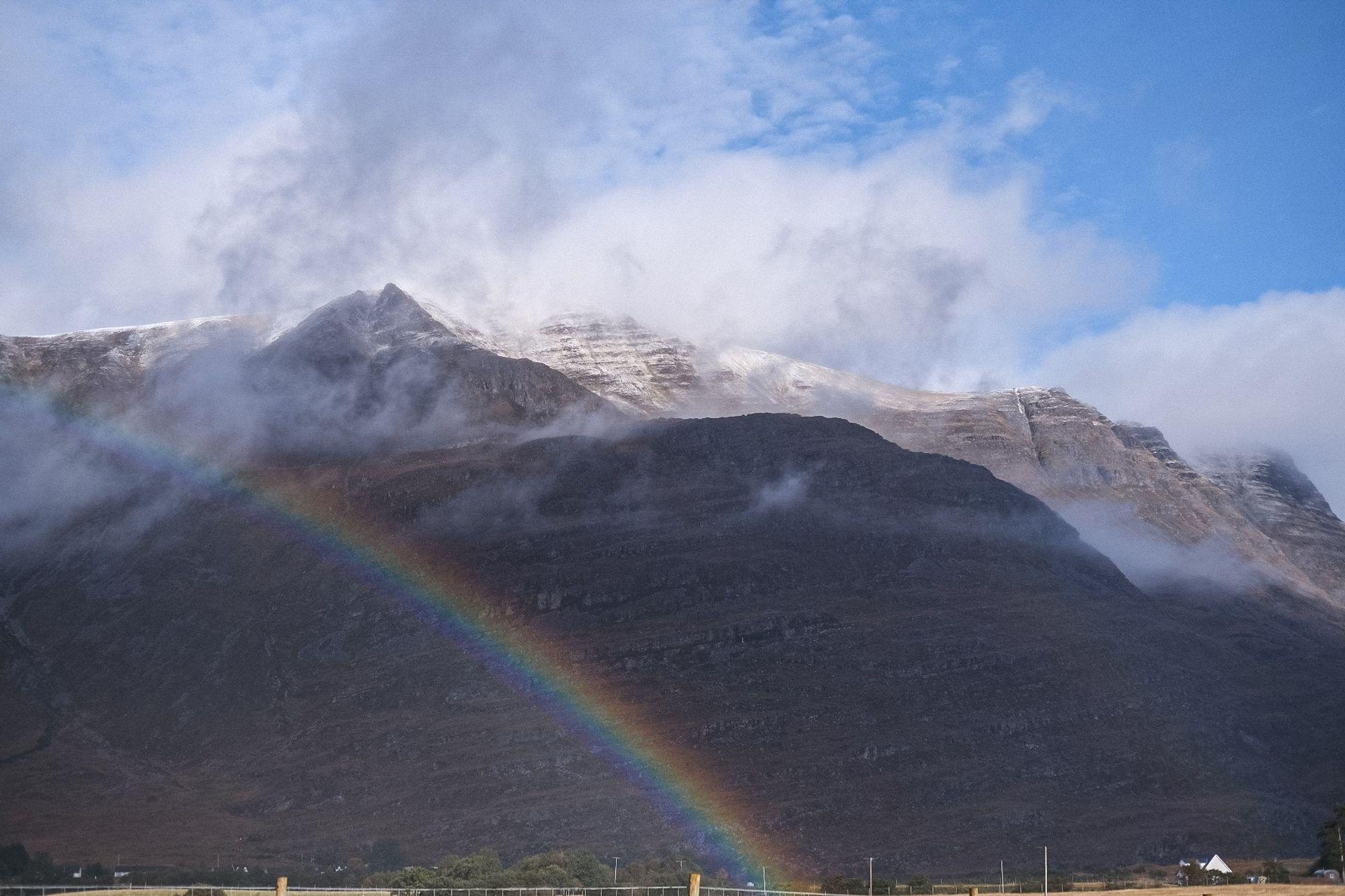 A colour photo of a rainbow as rain and sun pass through the Western end of Glen Torridon on a changeable October day. Wester Ross, Scottish Highlands. 

Photo by and copyright of Lynn Henni.