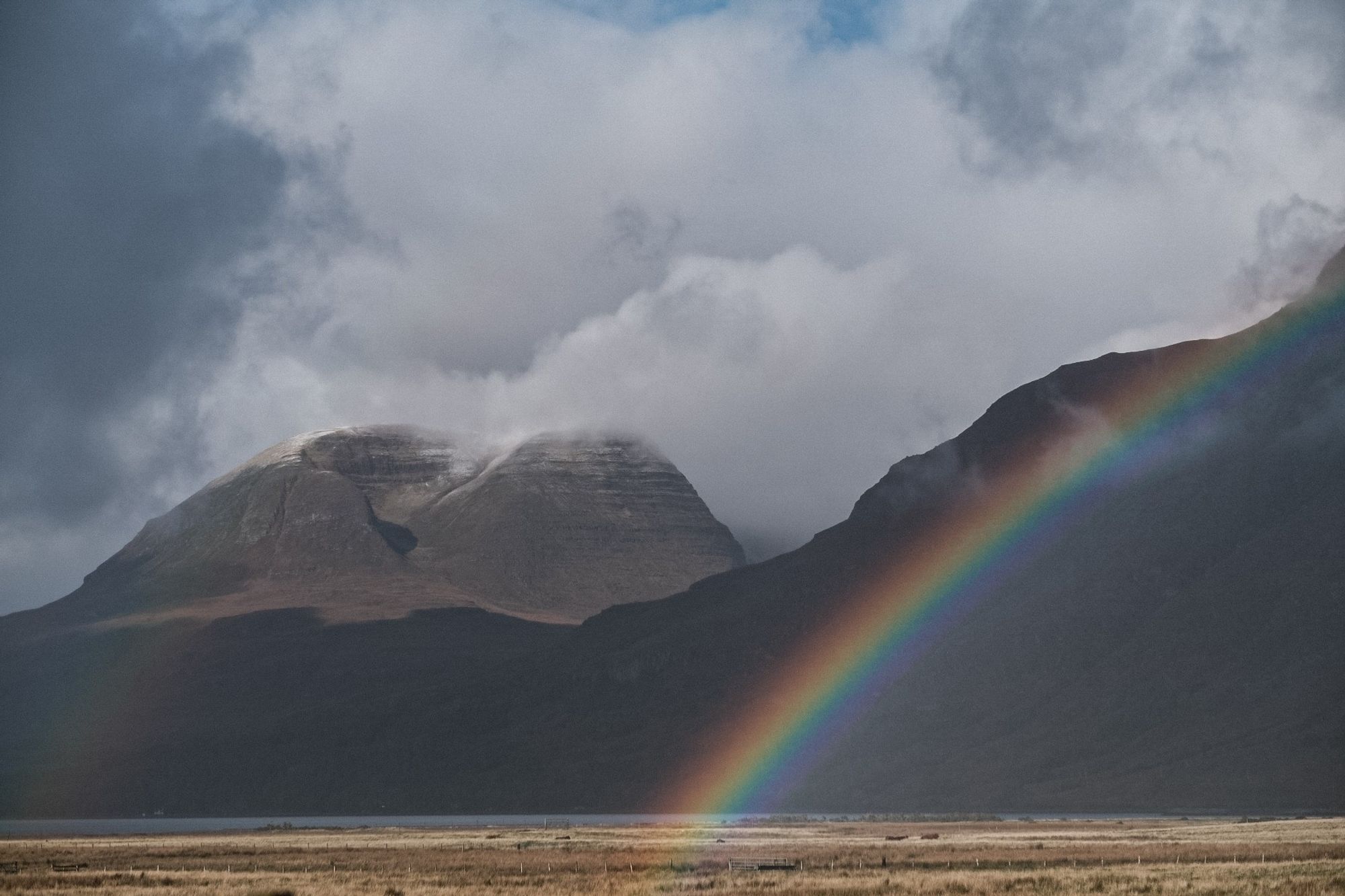 A colour photo of a rainbow as rain and sun pass through the Western end of Glen Torridon on a changeable October day. Wester Ross, Scottish Highlands. 

Photo by and copyright of Paul Henni.