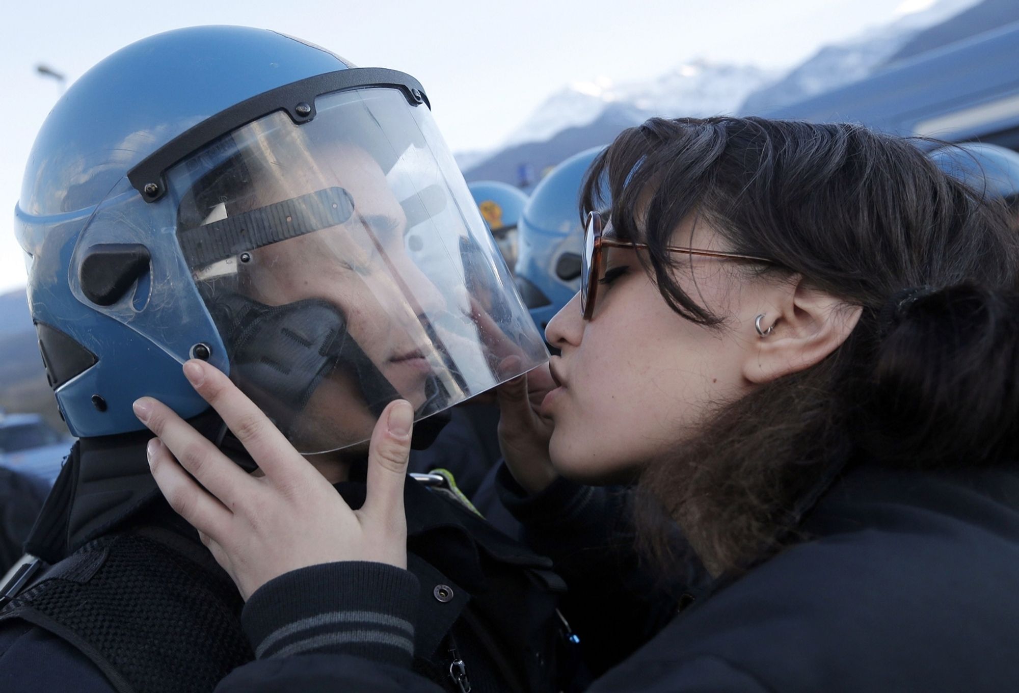 photo of someone trying to kiss a cop in riot gear