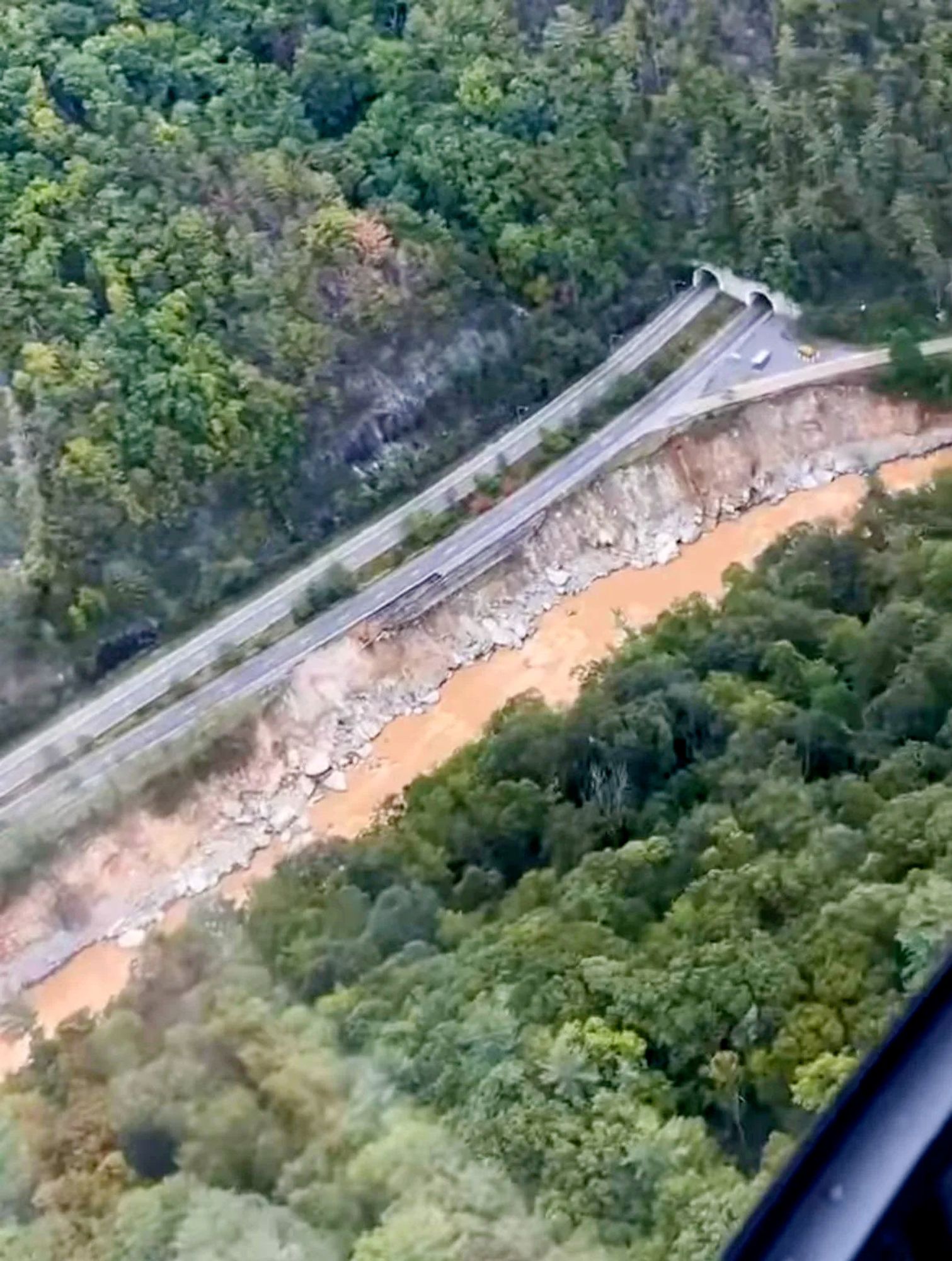 I-40 showing multiple areas of damage along the Pigeon River in NC near the tunnel entrance at Mile Marker 4.0