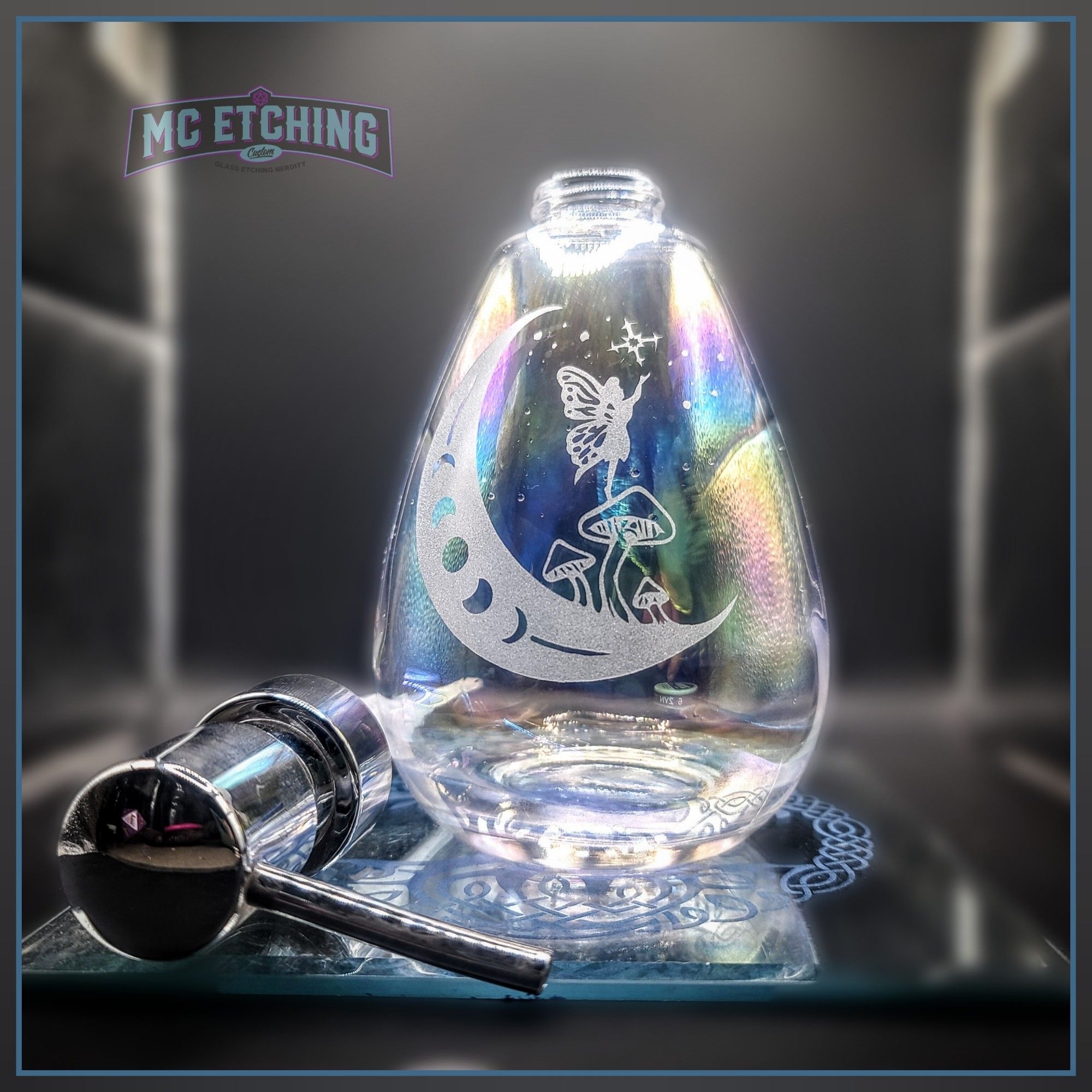 teardrop shaped iridescent glass hand soap pump with an etching of a moon with mushrooms and a little fairy girl standing atop the tallest mushroom reaching up to a star