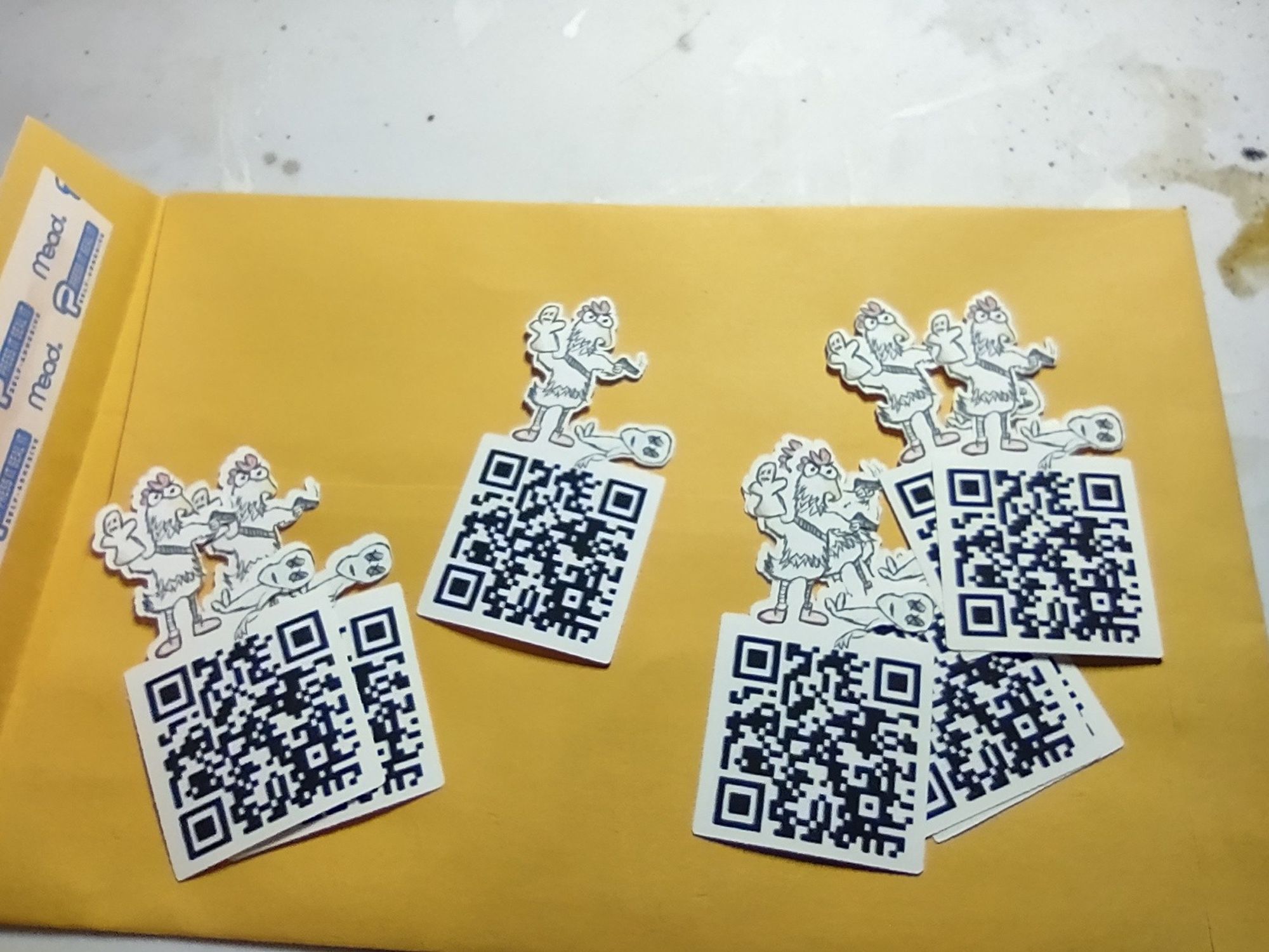 Homemade stickers. A chicken standing over an alien corpse holding a smoking gun, standing on a QR code.