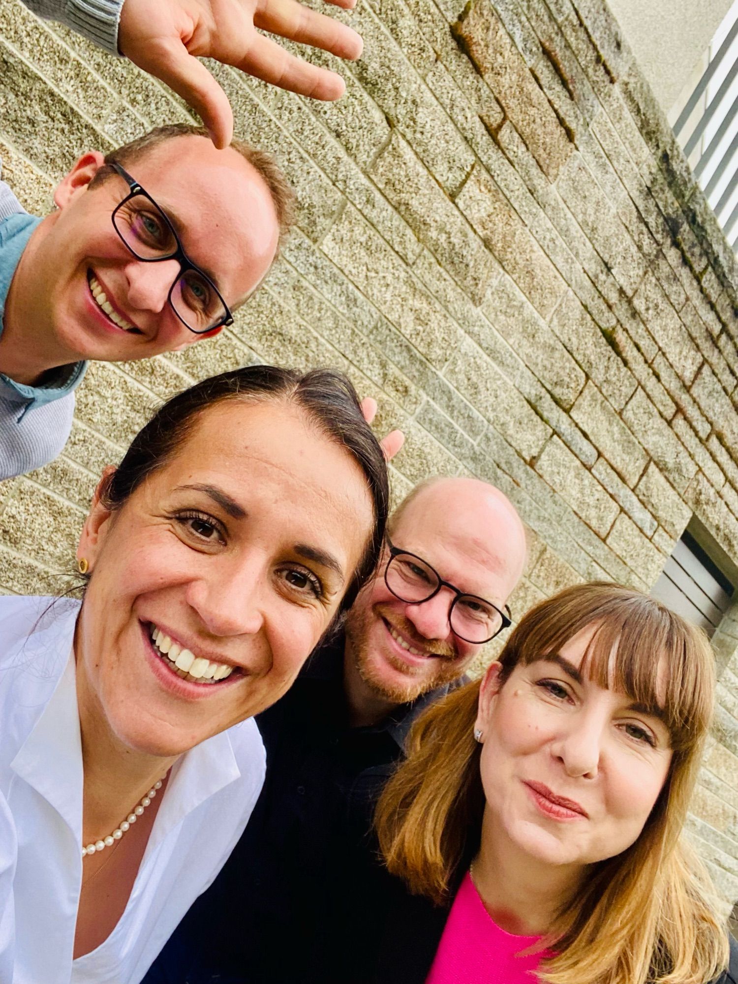 Four people smiling at the camera in front of the building. @pfefferle @dierennerin @flippedmathe