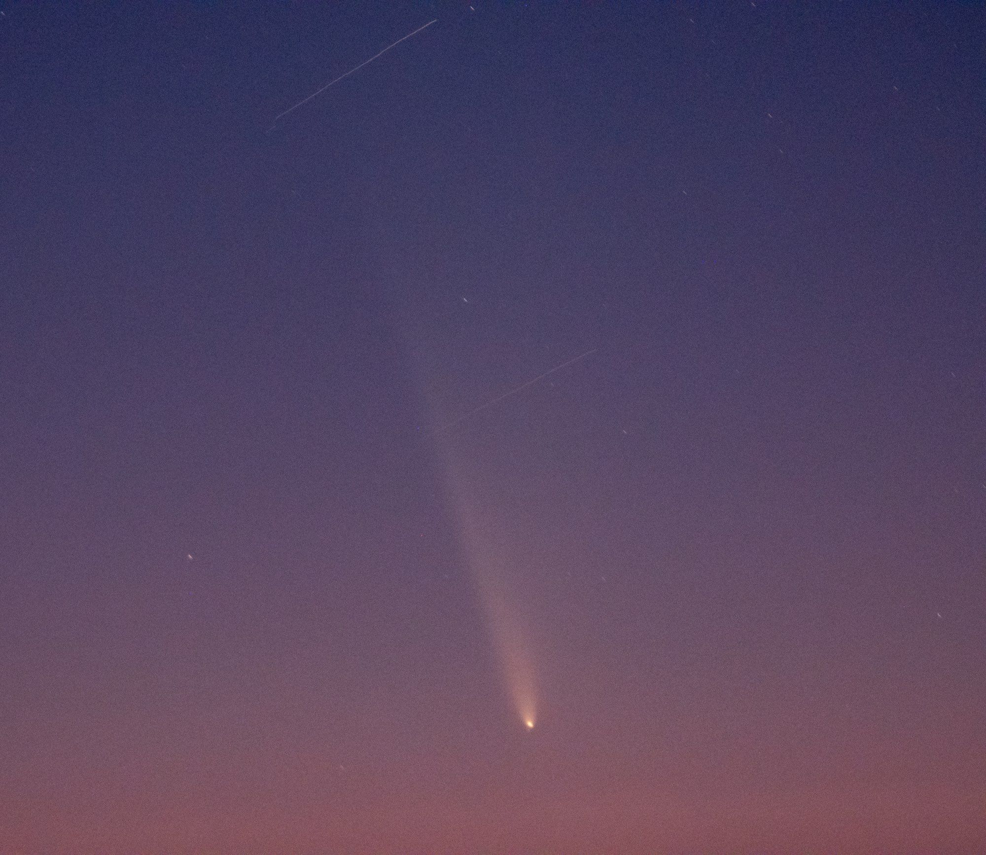 Purple desert sunset with an orange comet. Two satellites are photobombing.