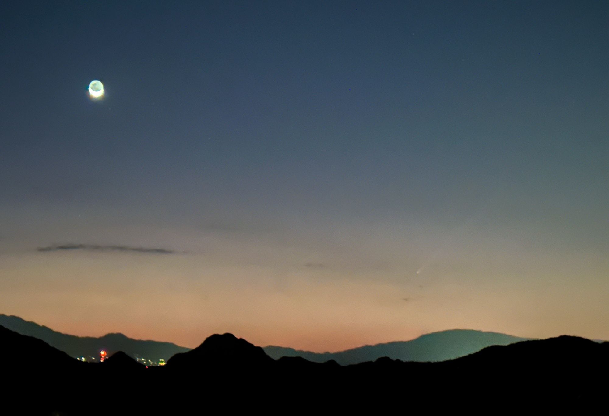 Moon rising over Tucson. There’s a comet visible to the right, the tail pointing away from the sun.