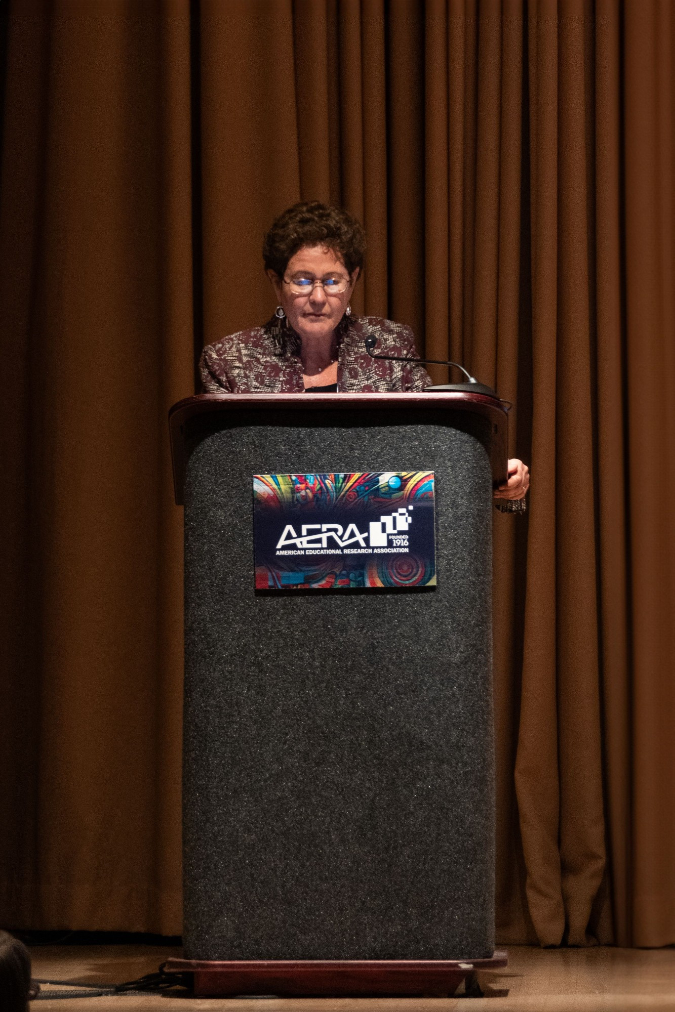 a person stands at a lectern speaking into a microphone