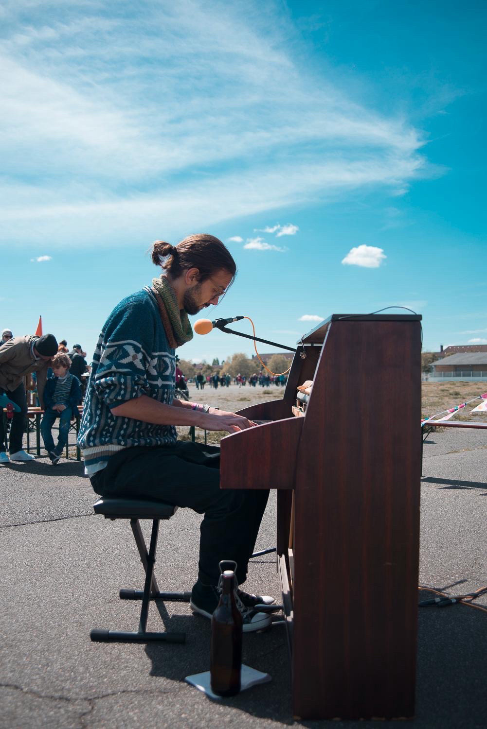 Feldmusik: ein junger Pianist spielt auf einem Klavier auf der Landebahn 